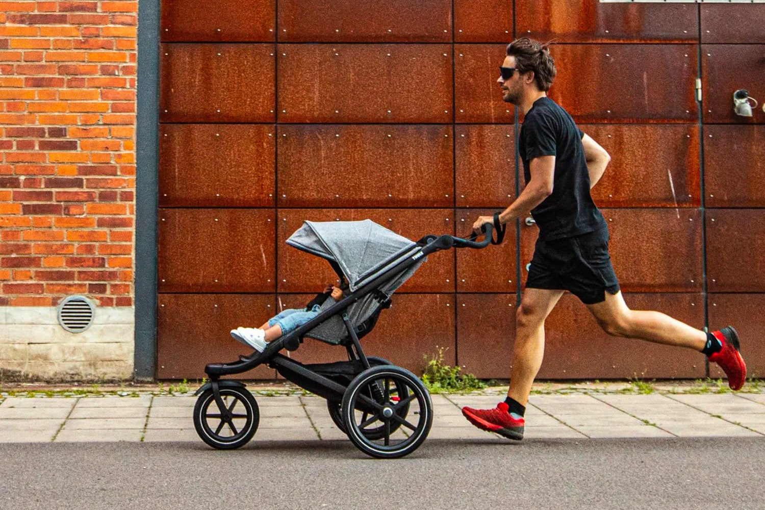 dad jogging with child in thule urban glide 2 jogging stroller
