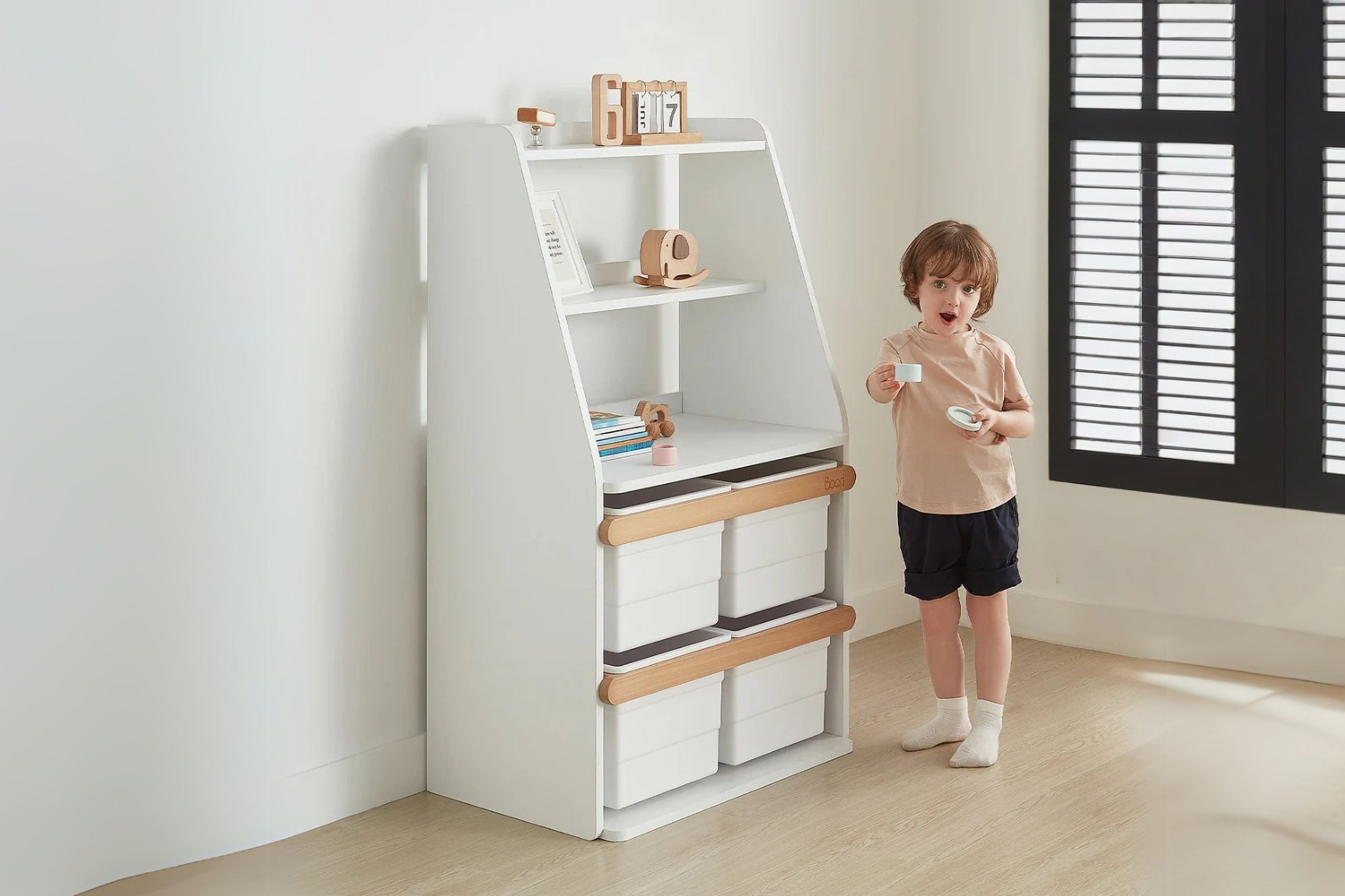 Child standing beside the Boori Tidy Integrated Storage Unit, placed in the corner of a cosy room