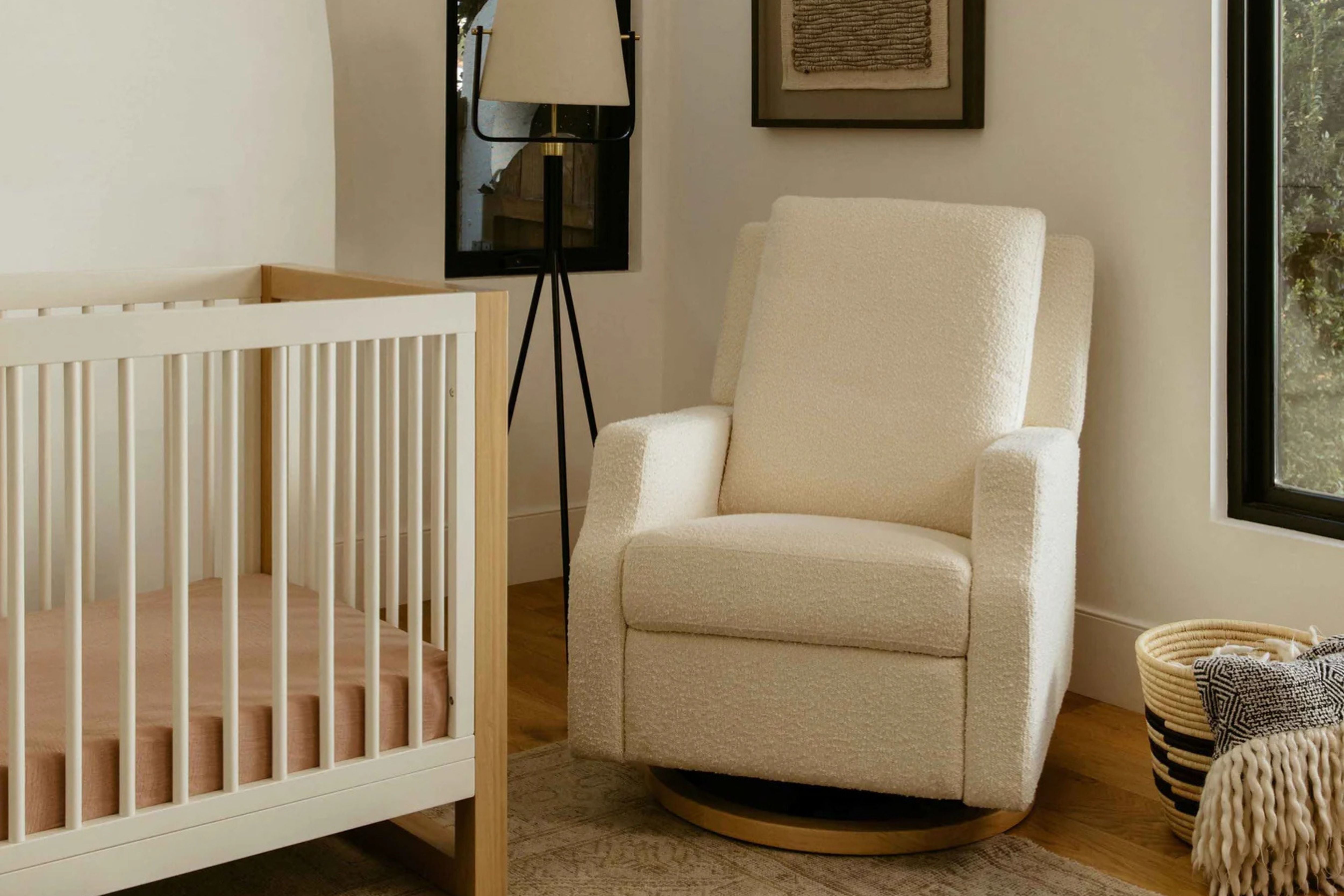 Namesake Crewe Recliner and Swivel Glider in Ivory Boucle with light wood base  displayed in a corner of a cosy nursery #color_crewe-ivory-boucle