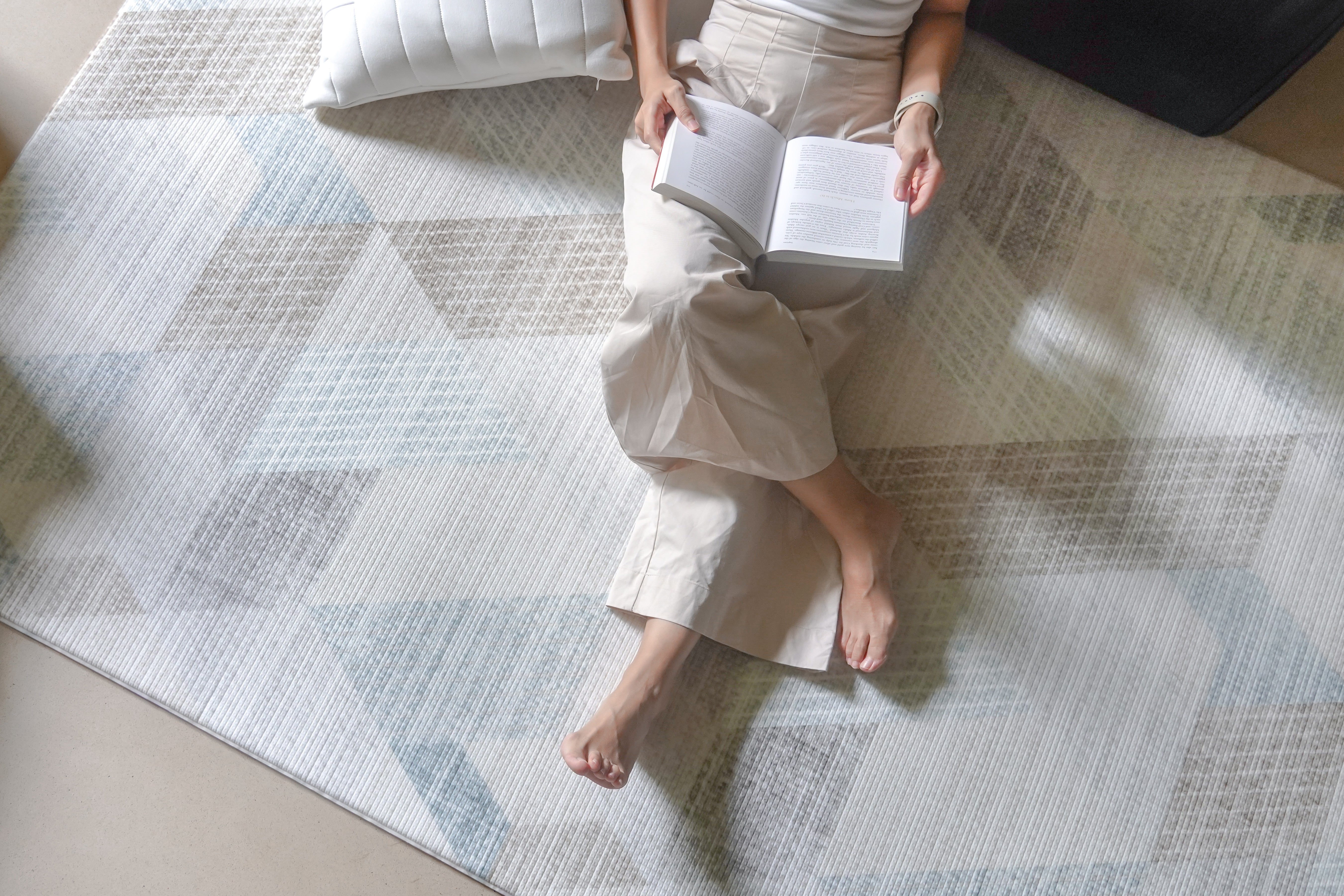 lady reading while sitting on lollibly snow dune play mat