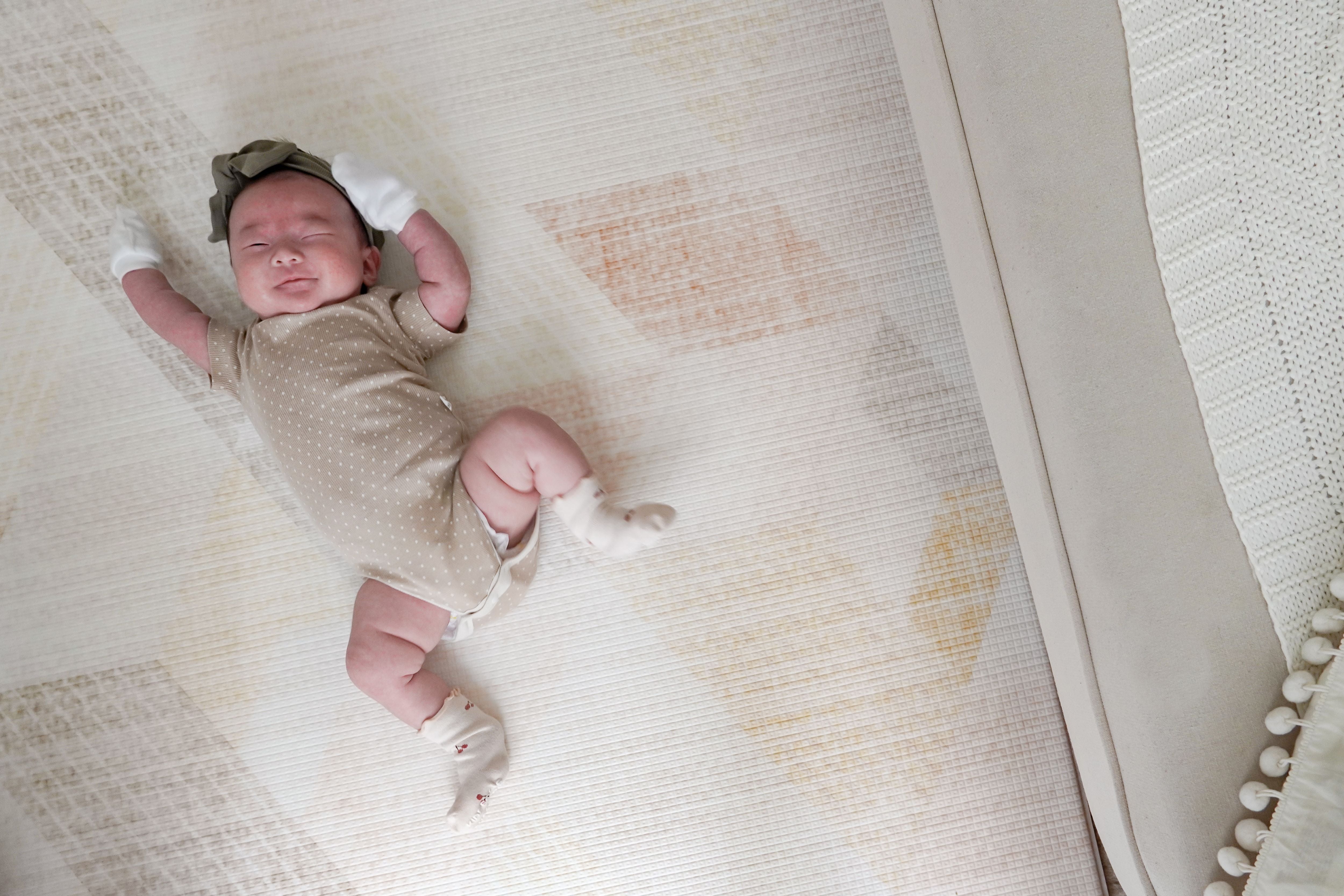 baby stretching on lollibly sand dune play mat