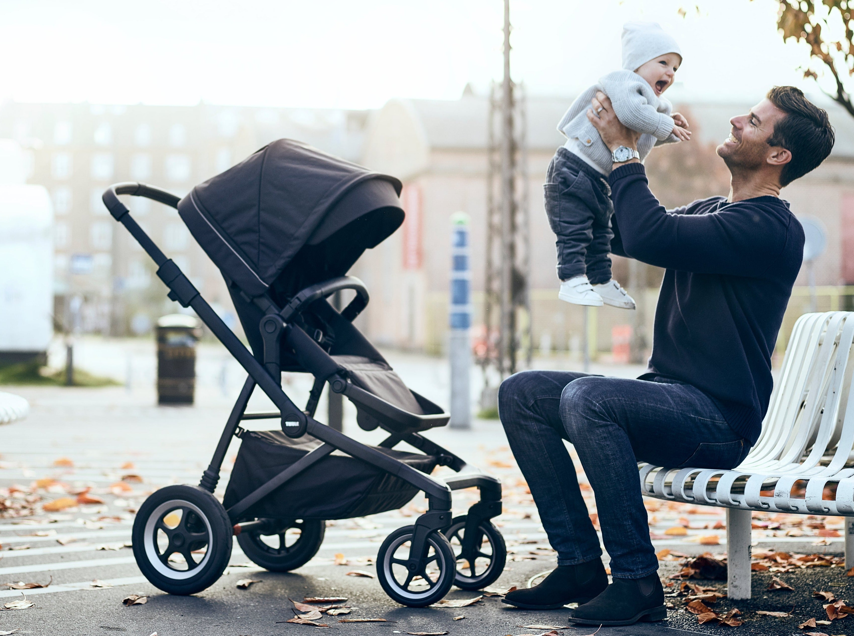 Dad playing with baby on park bench