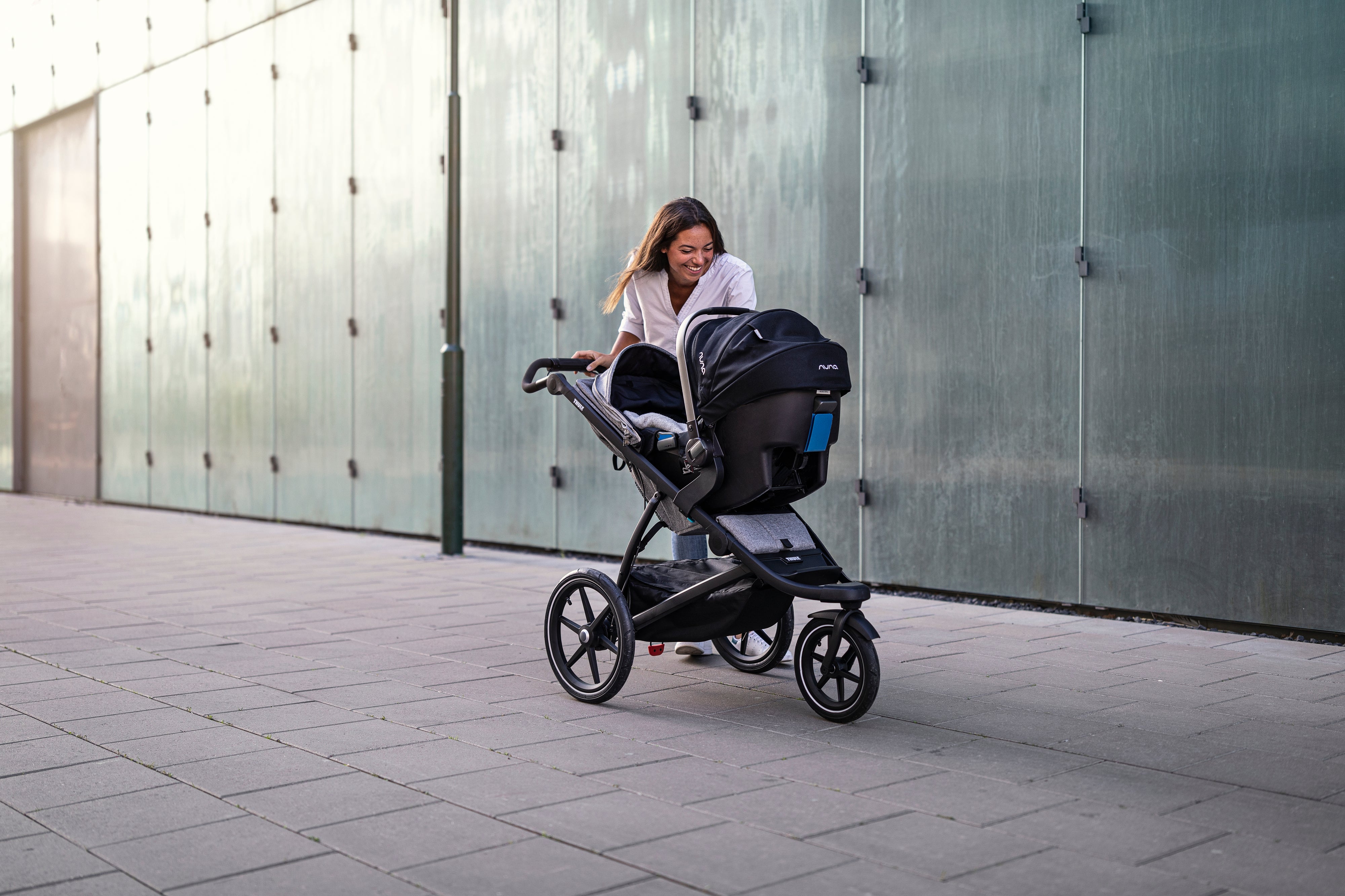 Mum pushing baby in Thule Urban Glide 2 stroller car seat adapter