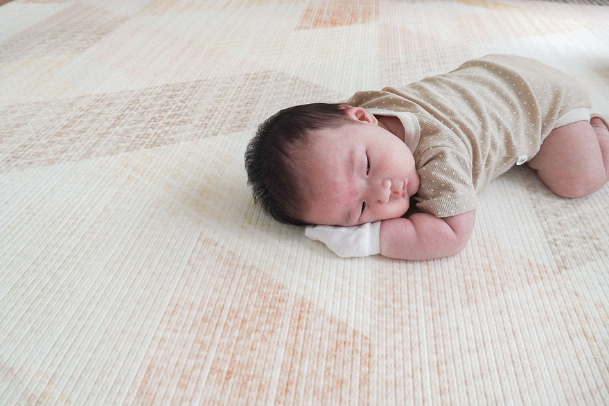 baby girl doing tummy time on lollibly sand dune playmat
