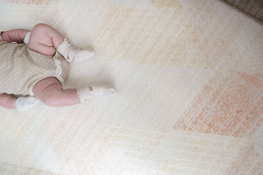 baby resting on lollibly sand dune playmat