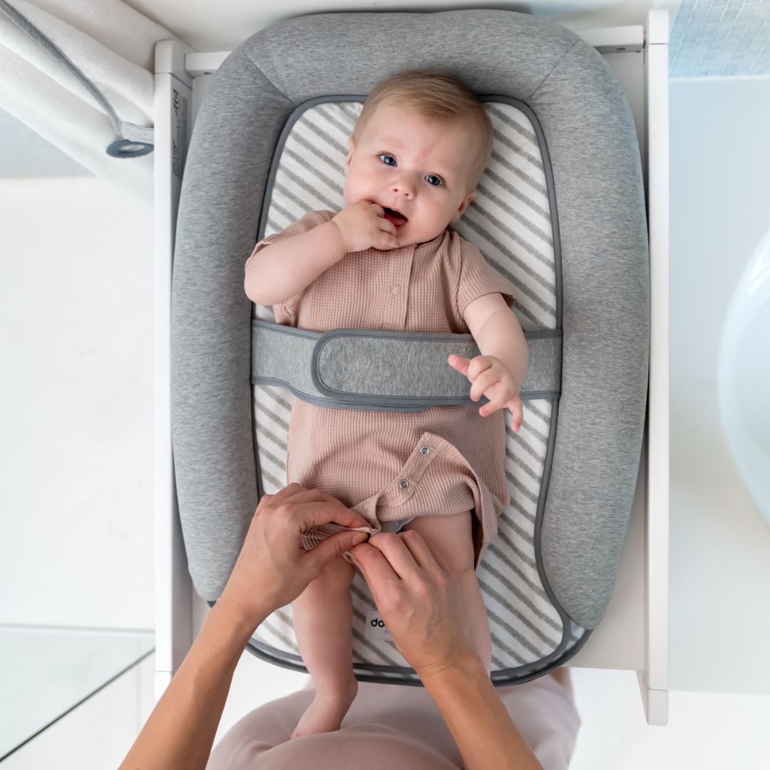 mum changing baby on doomoo changing pad