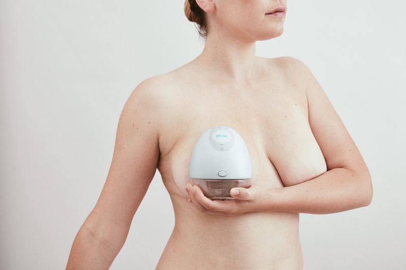 lady holding onto elvie wireless wearable breast pump