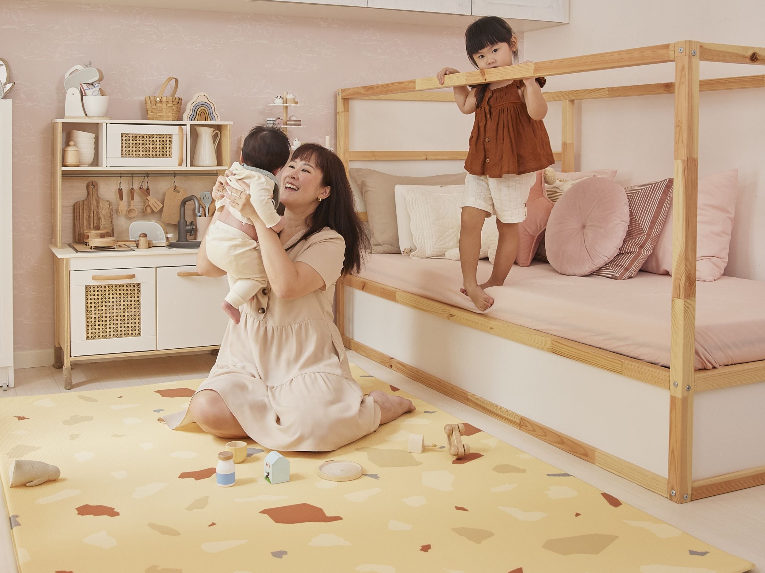 mom carrying baby boy on lollibly terrazzo play mat