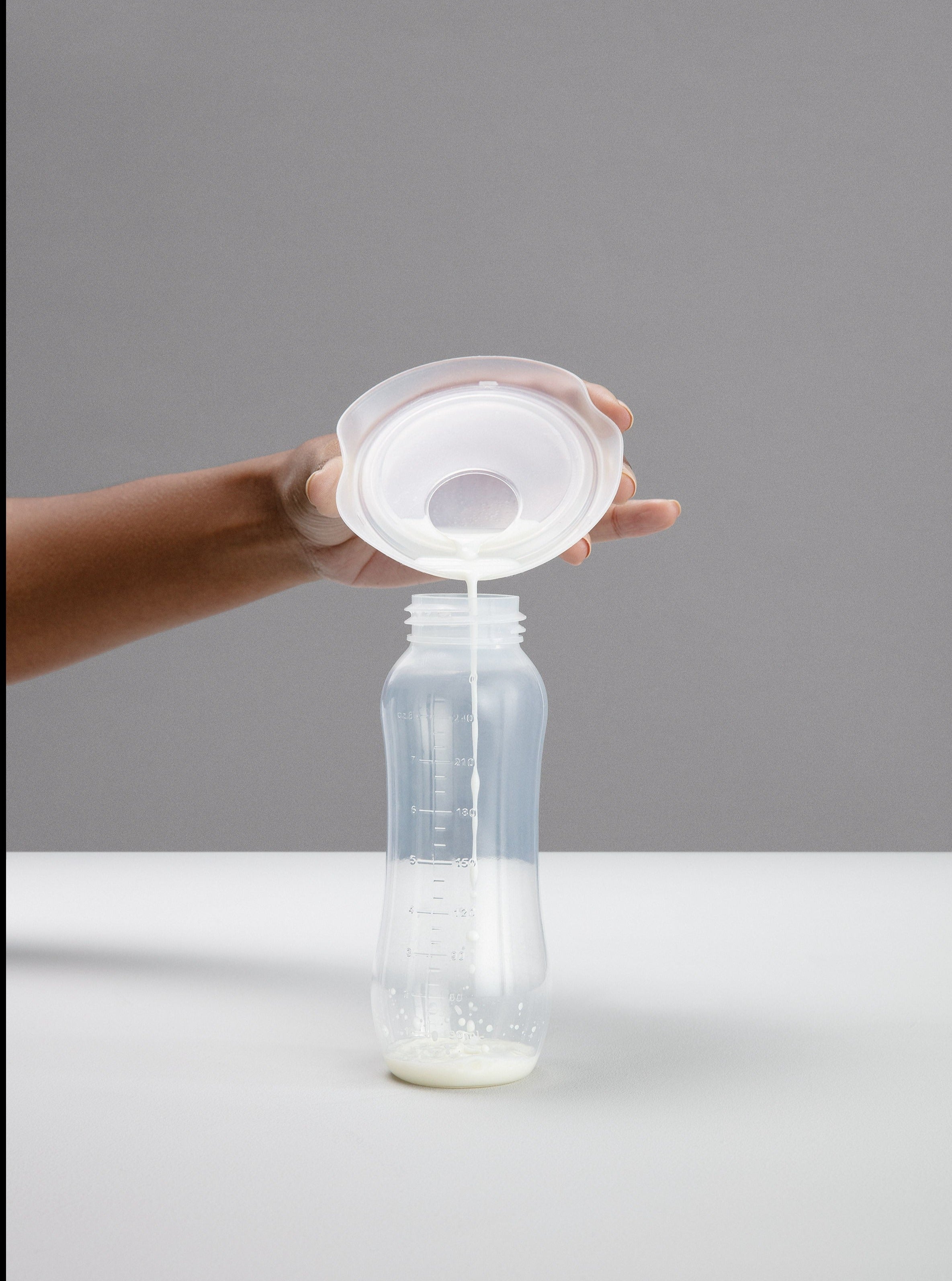 elvie catch with milk poured into bottle