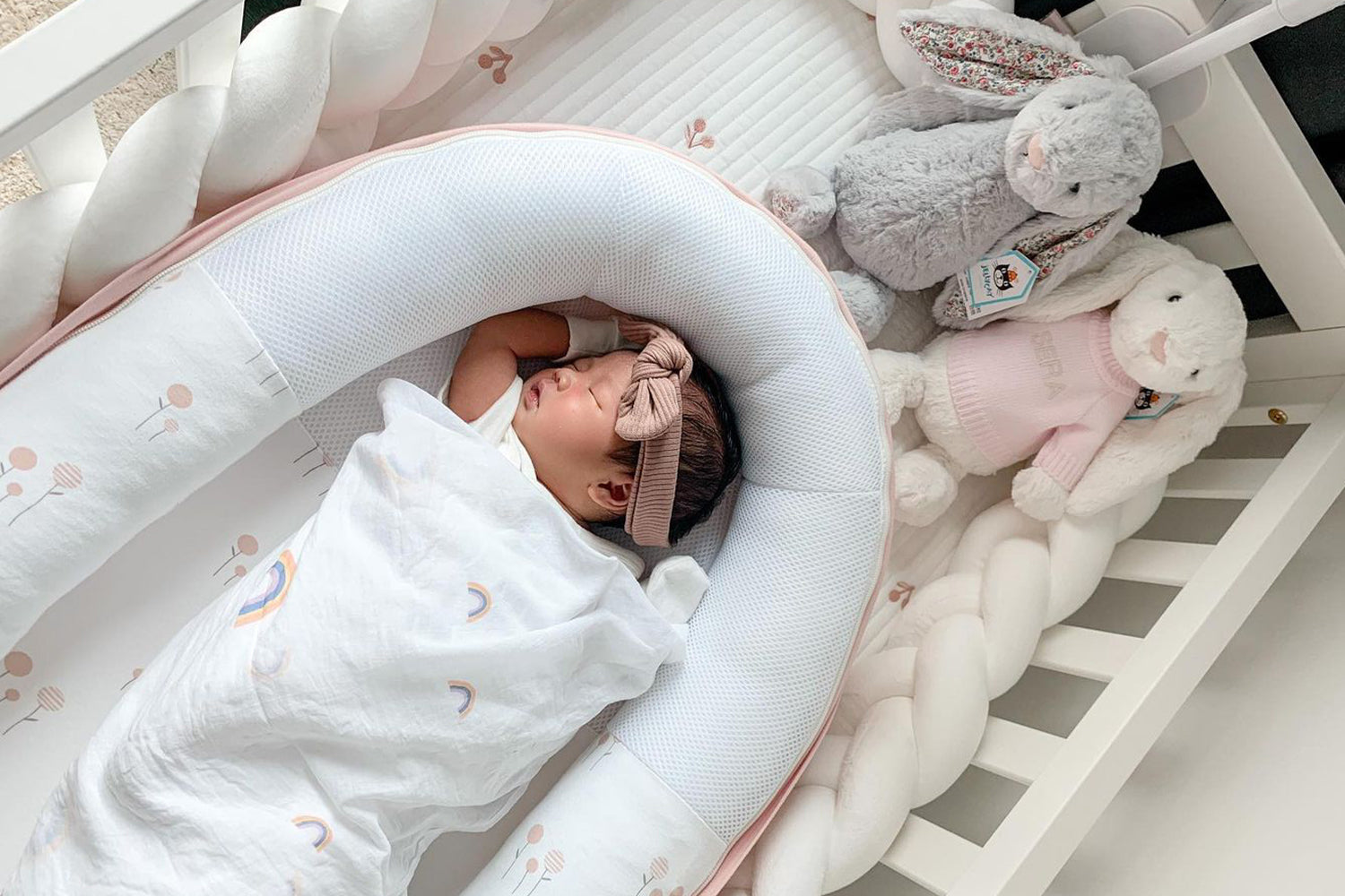 baby sleeping peacefully in cocoon in crib