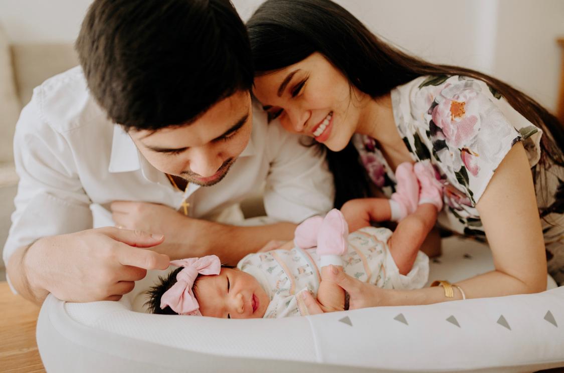 Mum and dad hugging newborn baby girl