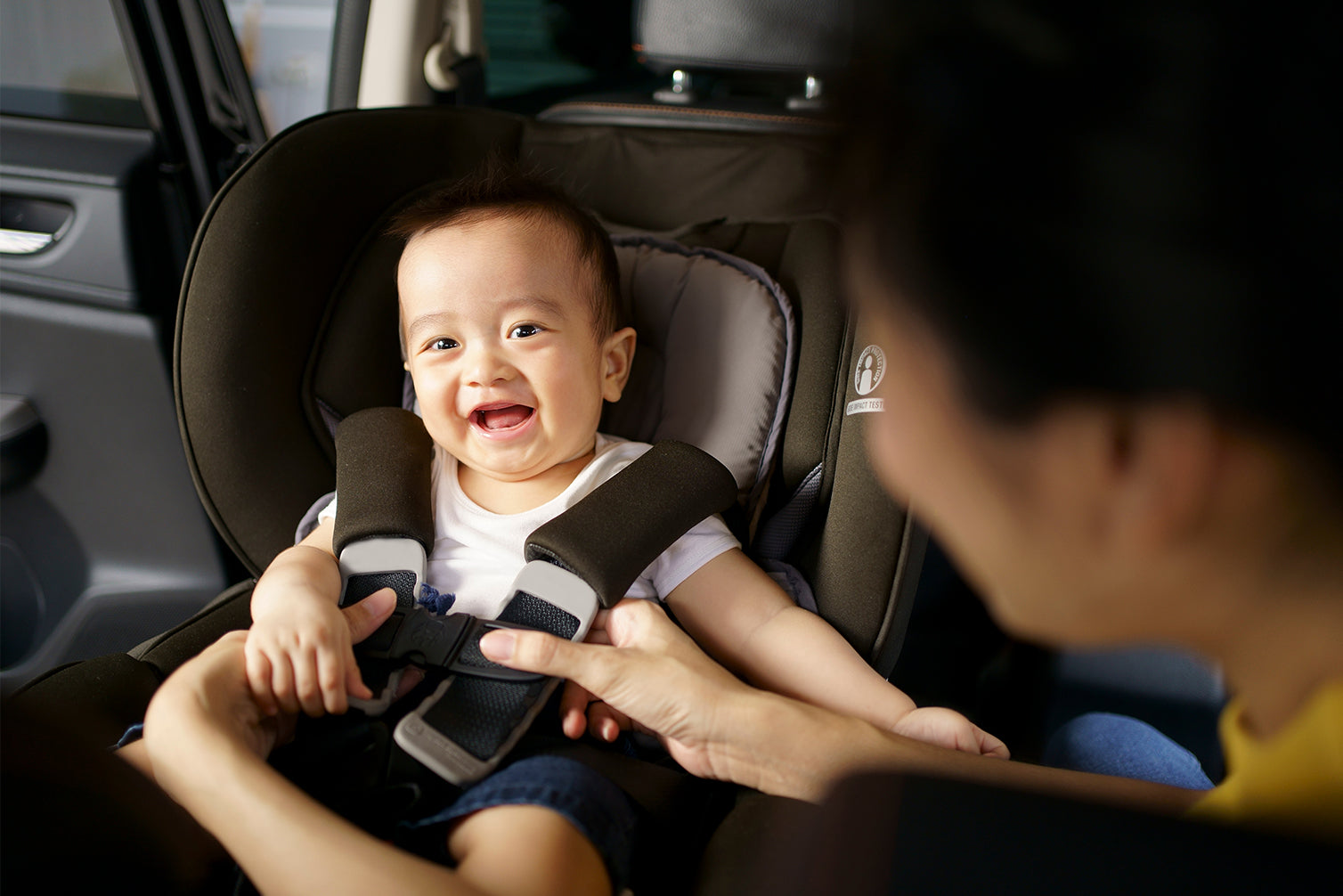 parent making baby sit on car seat