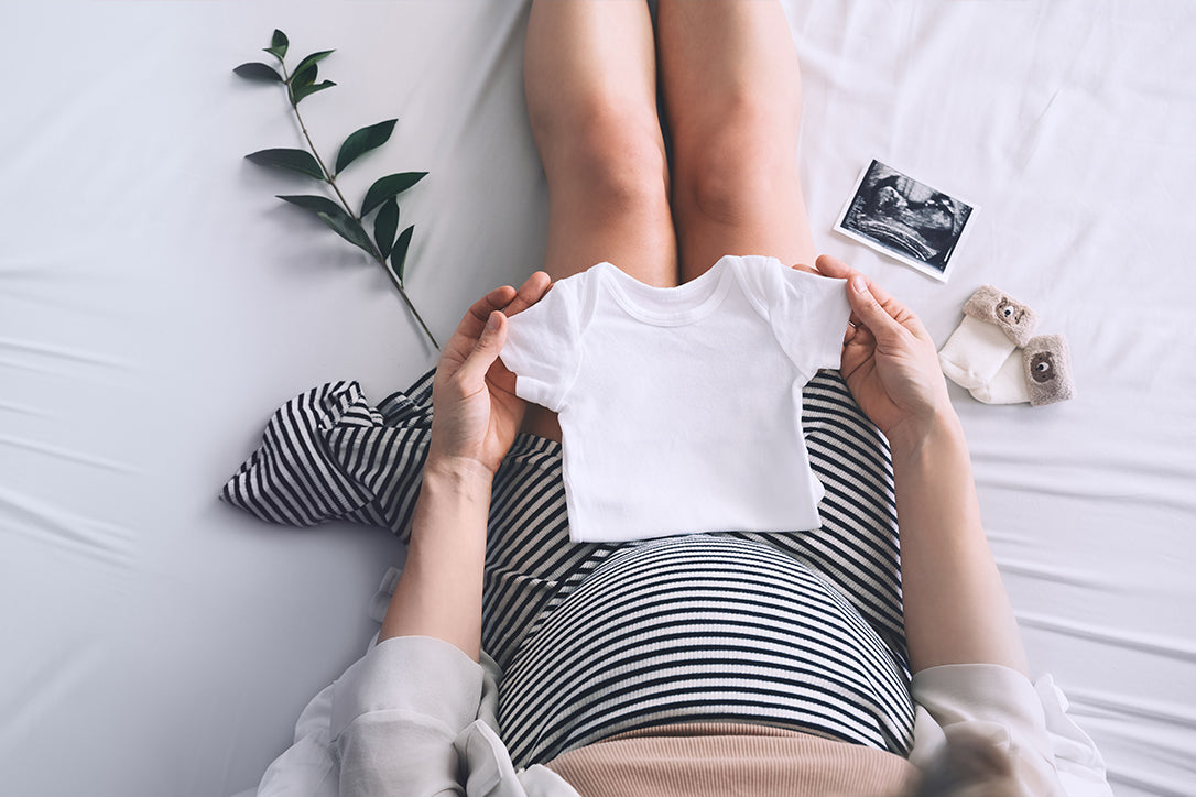 pregnant woman preparing baby clothes