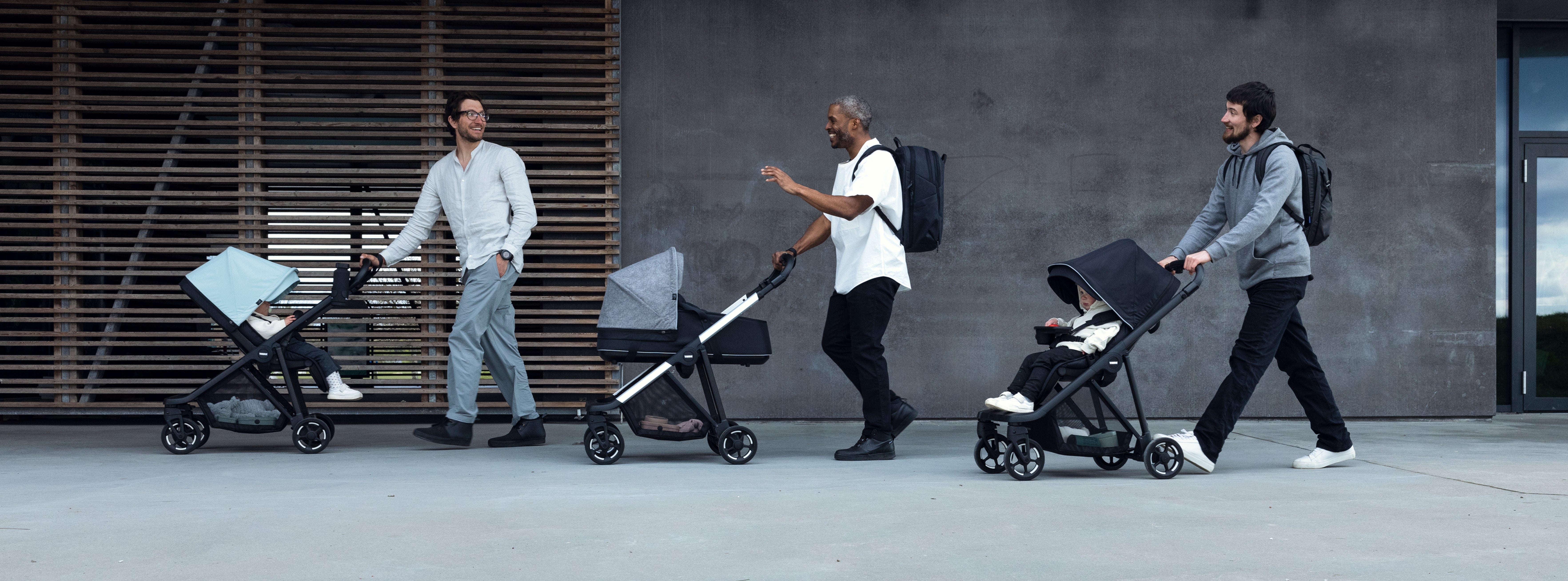 Dads pushing baby and toddler in thule strollers in the city