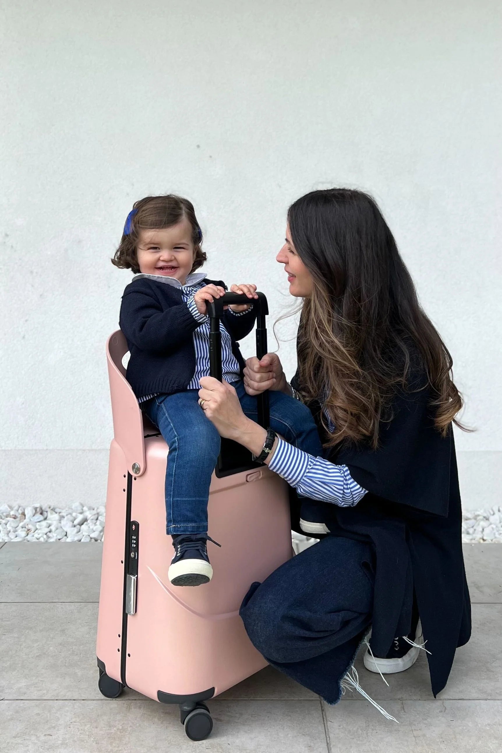 little girl sitting on miamily pink 18inch luggage