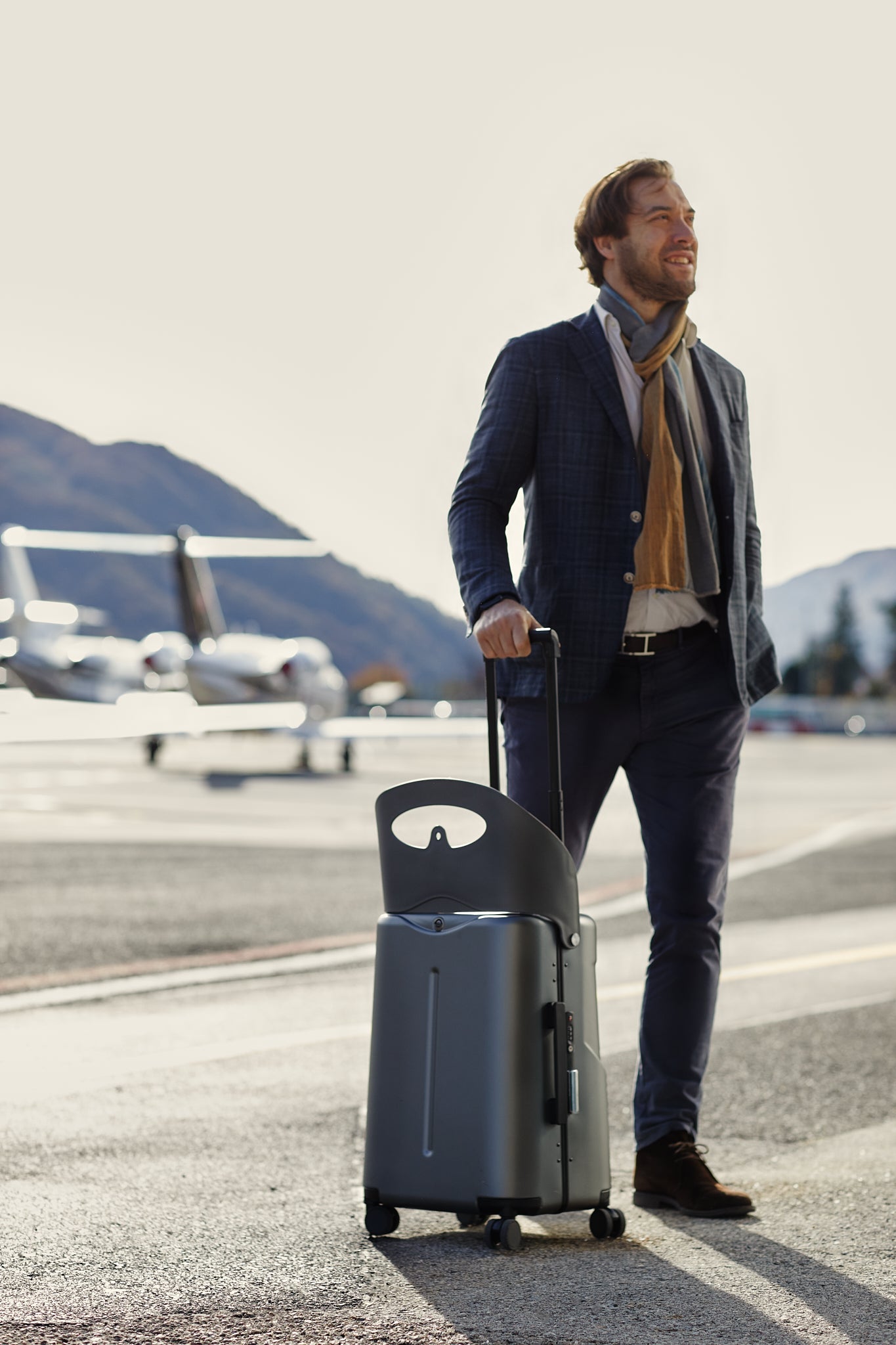 business man posing with miamily luggage charcoal grey