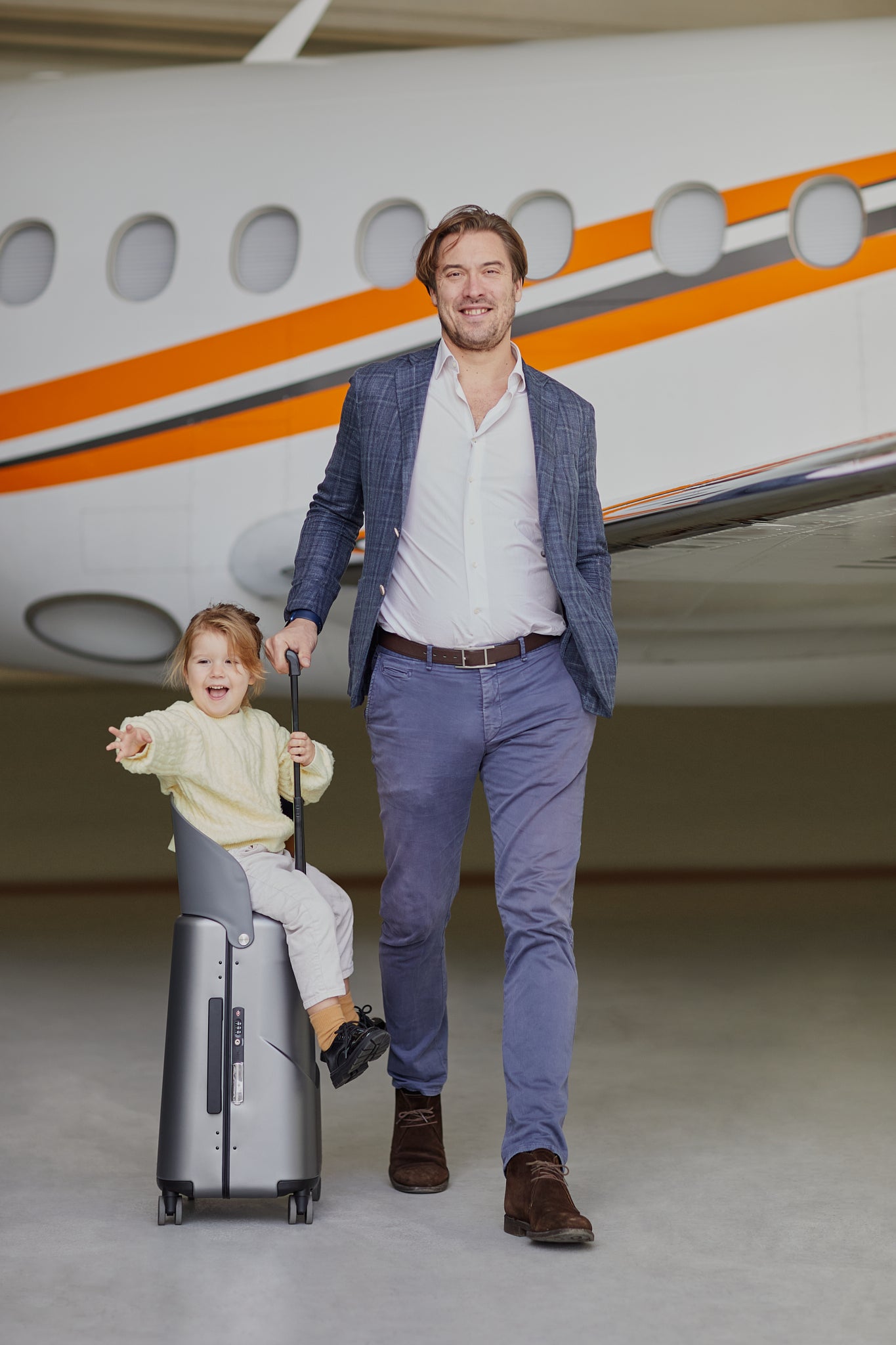 business man with child sitting on miamily luggage charcoal grey