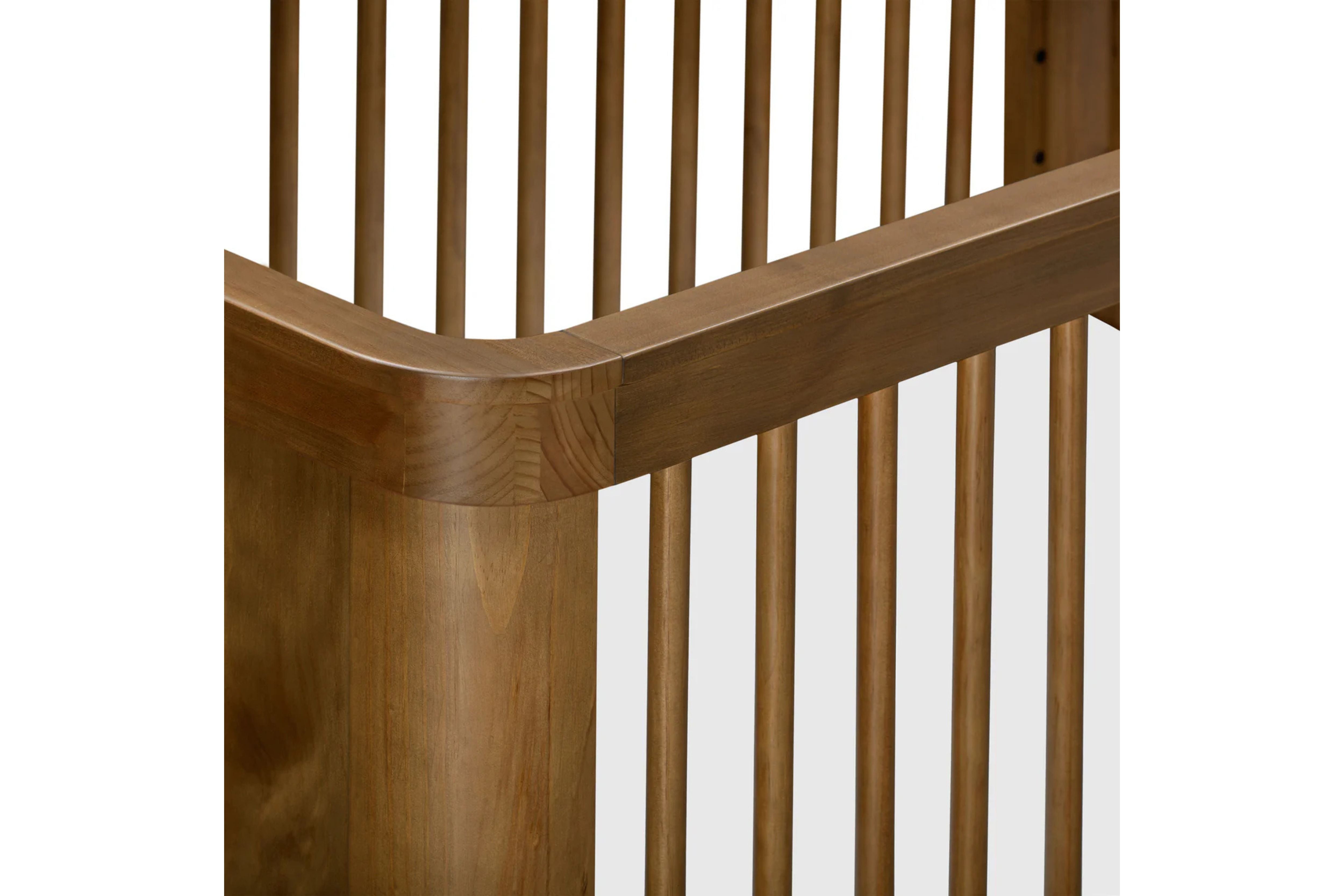 Close-up view of the Babyletto Crosby 3-in-1 Convertible Crib in Walnut finish #color_walnut