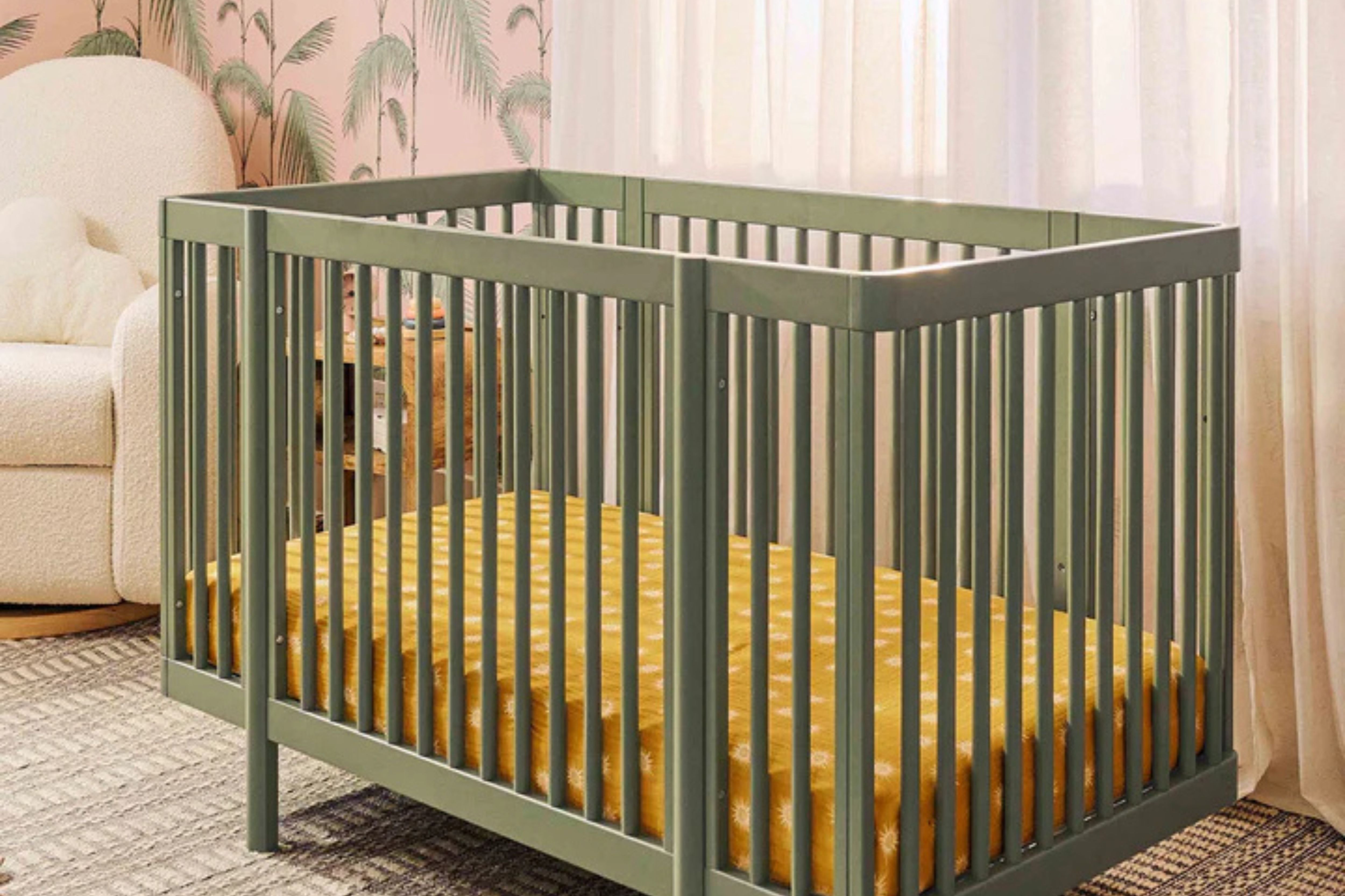 Babyletto olive pogo 8-in-1-convertible crib full size crib placed beside a nursing chair in a nursery#color_olive