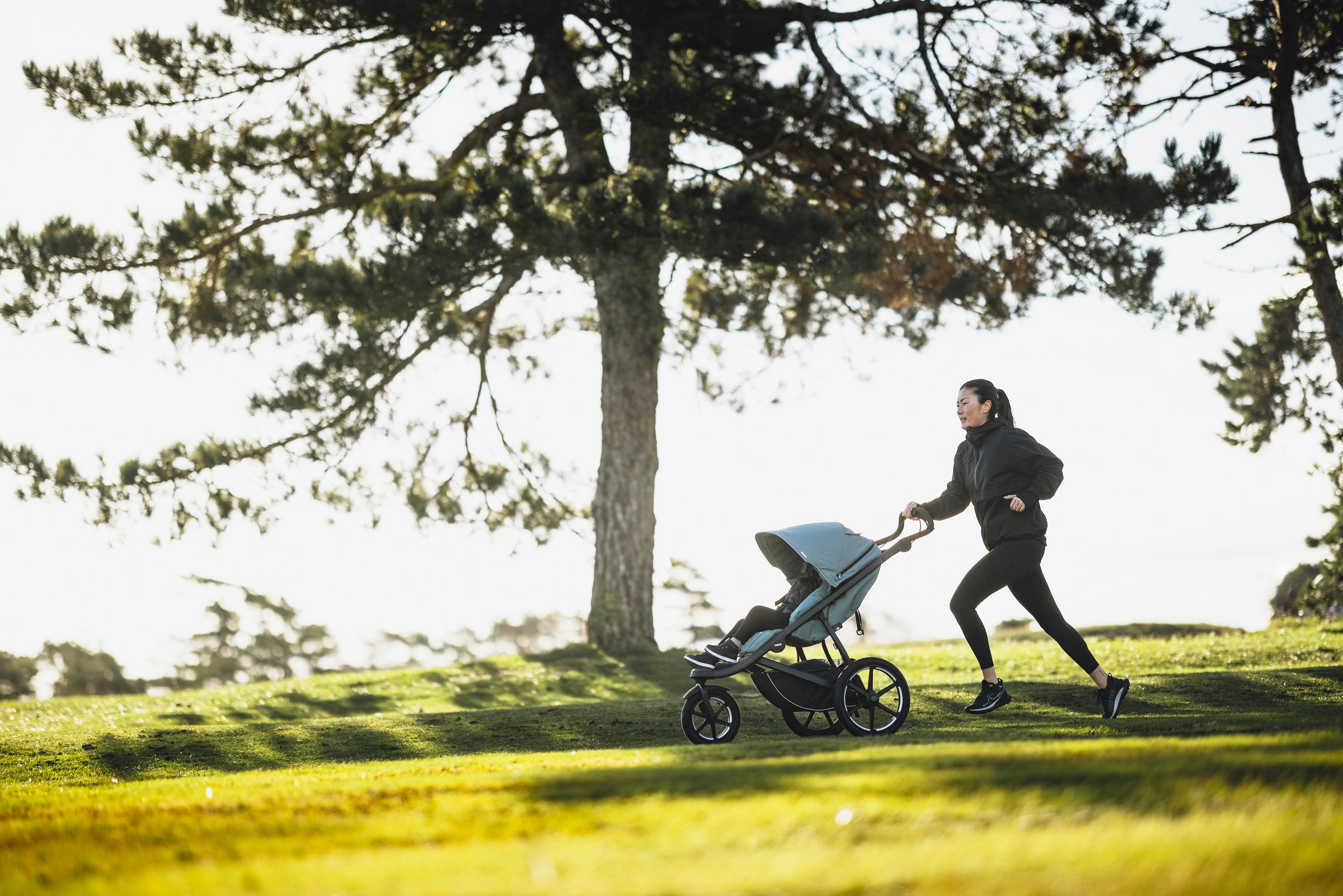 mother jogging with baby in jogging stroller outdoor nature