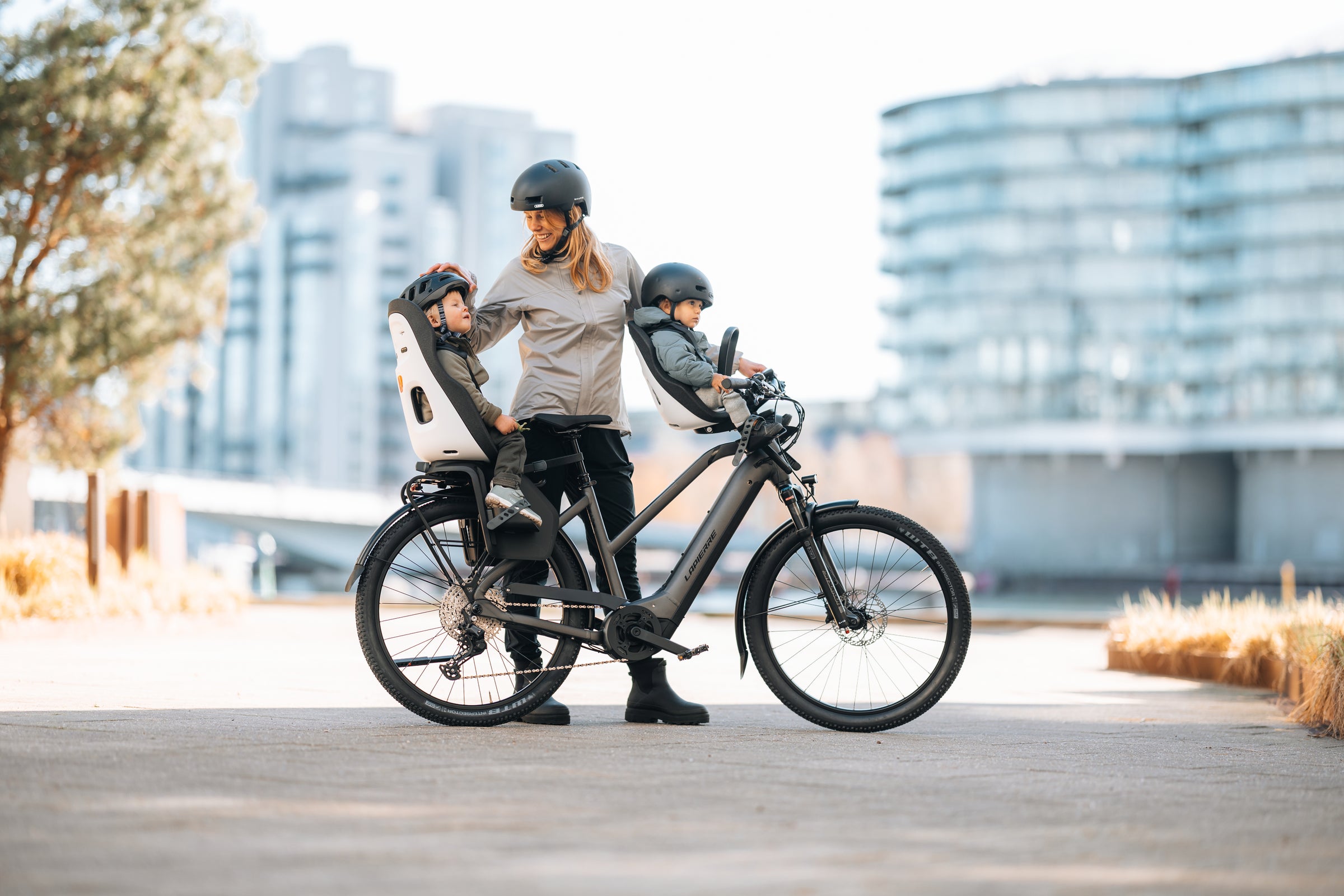 mother toddler and baby on bicycle child bike seats with helmet on the go