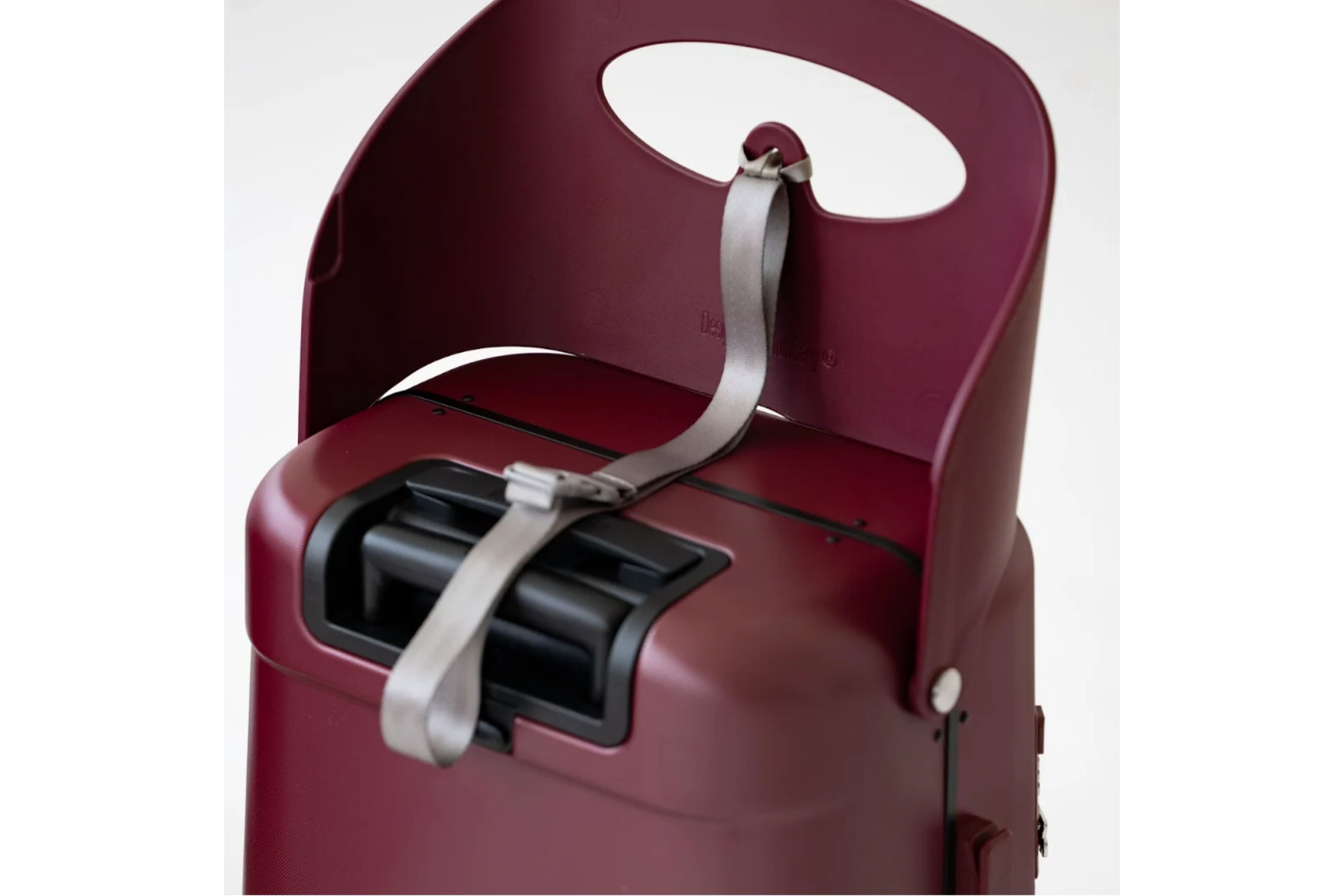 A close-up of the MiaMily Carry On Plus 18” Luggage’s built-in ride-on seat with its safety belt securely fastened