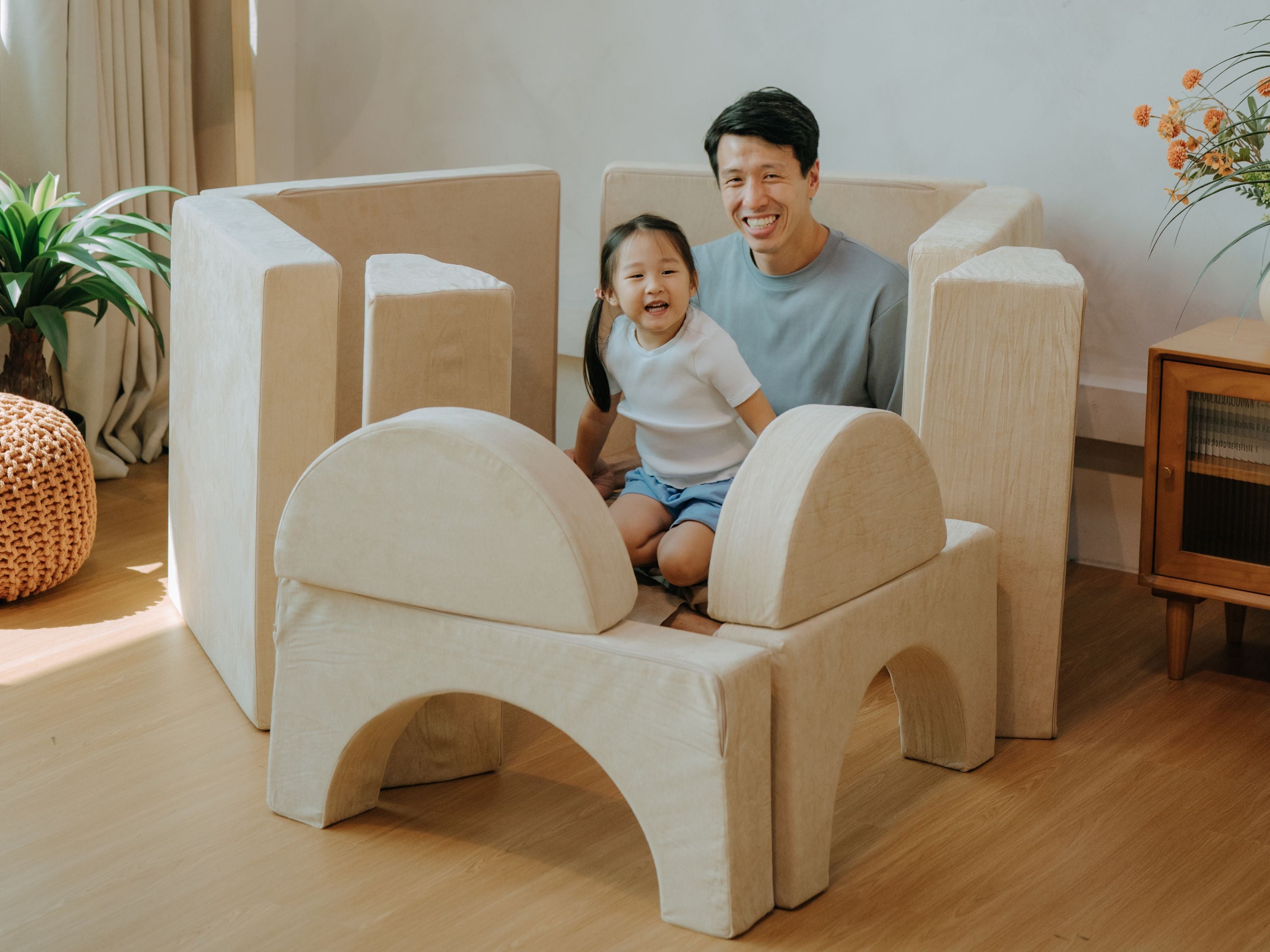 Child and dad smiling happily while sitting inside a structure built by the child using the Lollibly Wonderstack Play Sofa