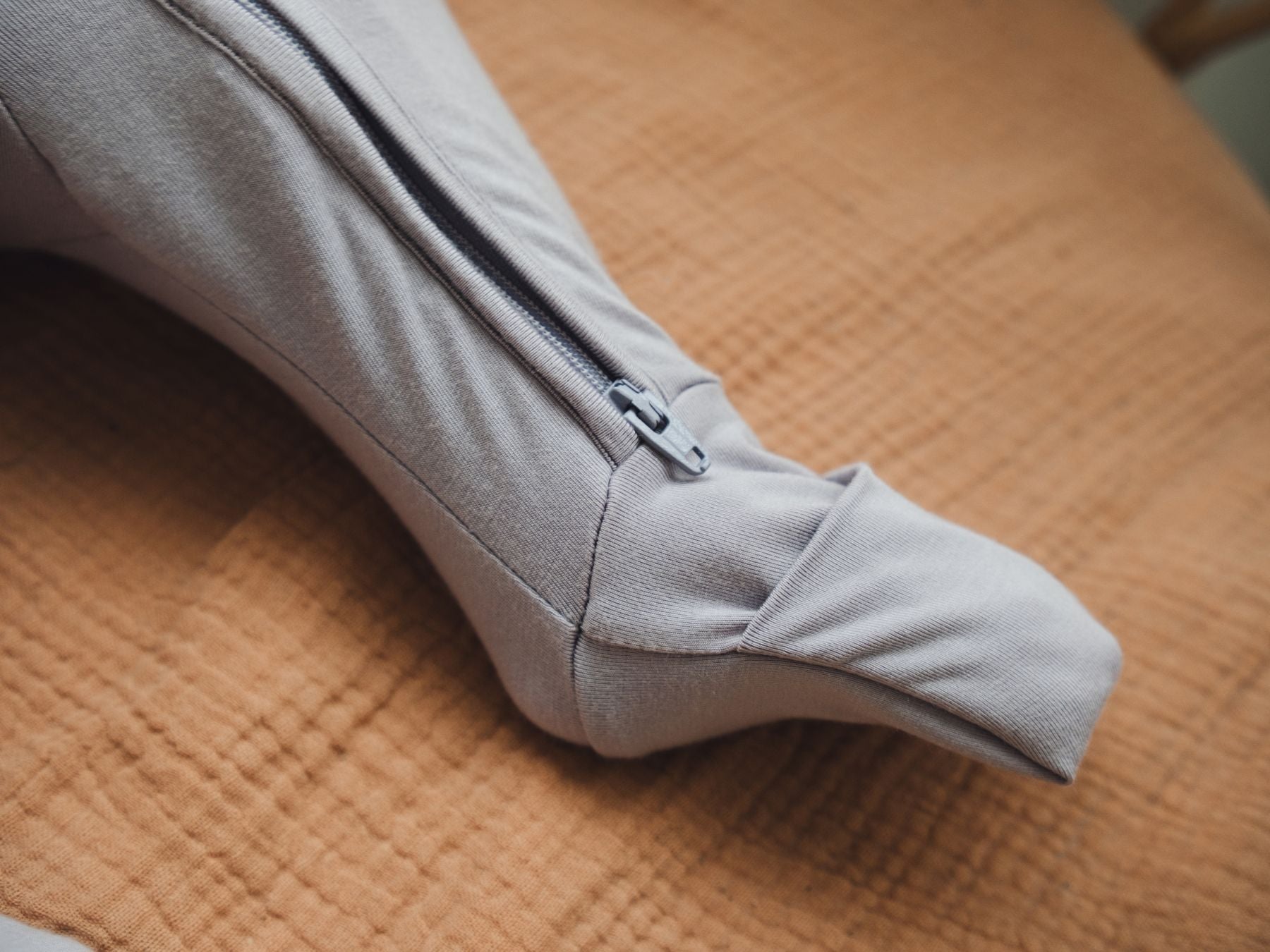 Close-up showing the fold-over leg mitten of a baby sleep suit