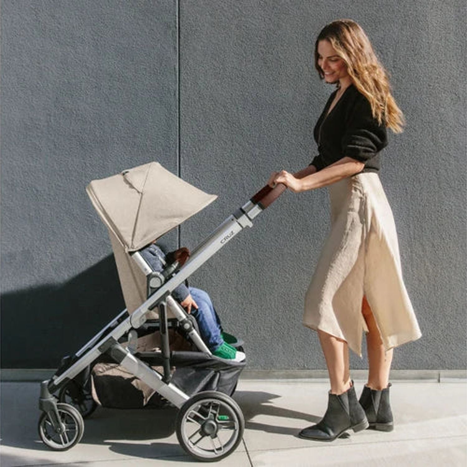 Mother taking her baby out on the Uppababy Cruz 2 Declan Reversible Stroller#color_declan