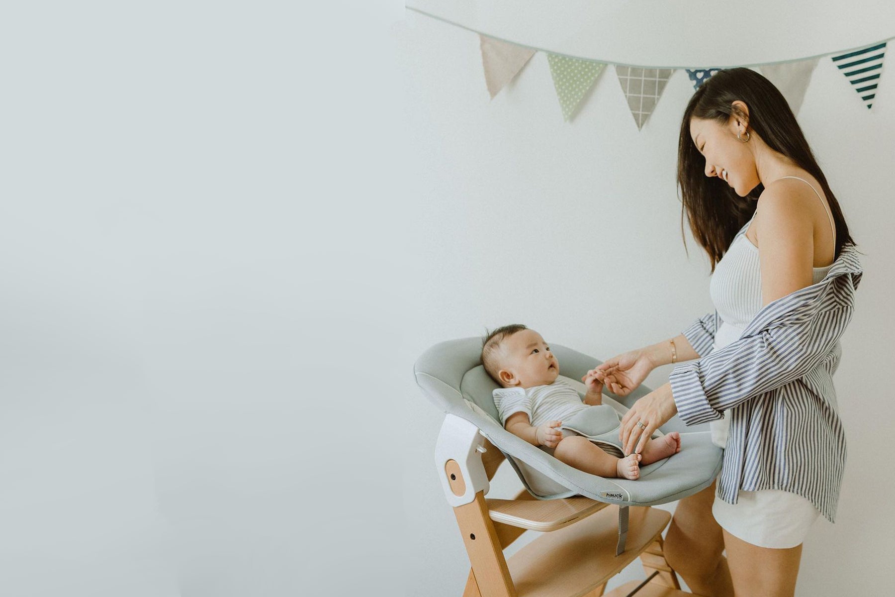 mum smiling at baby on high chair with infant bouncer