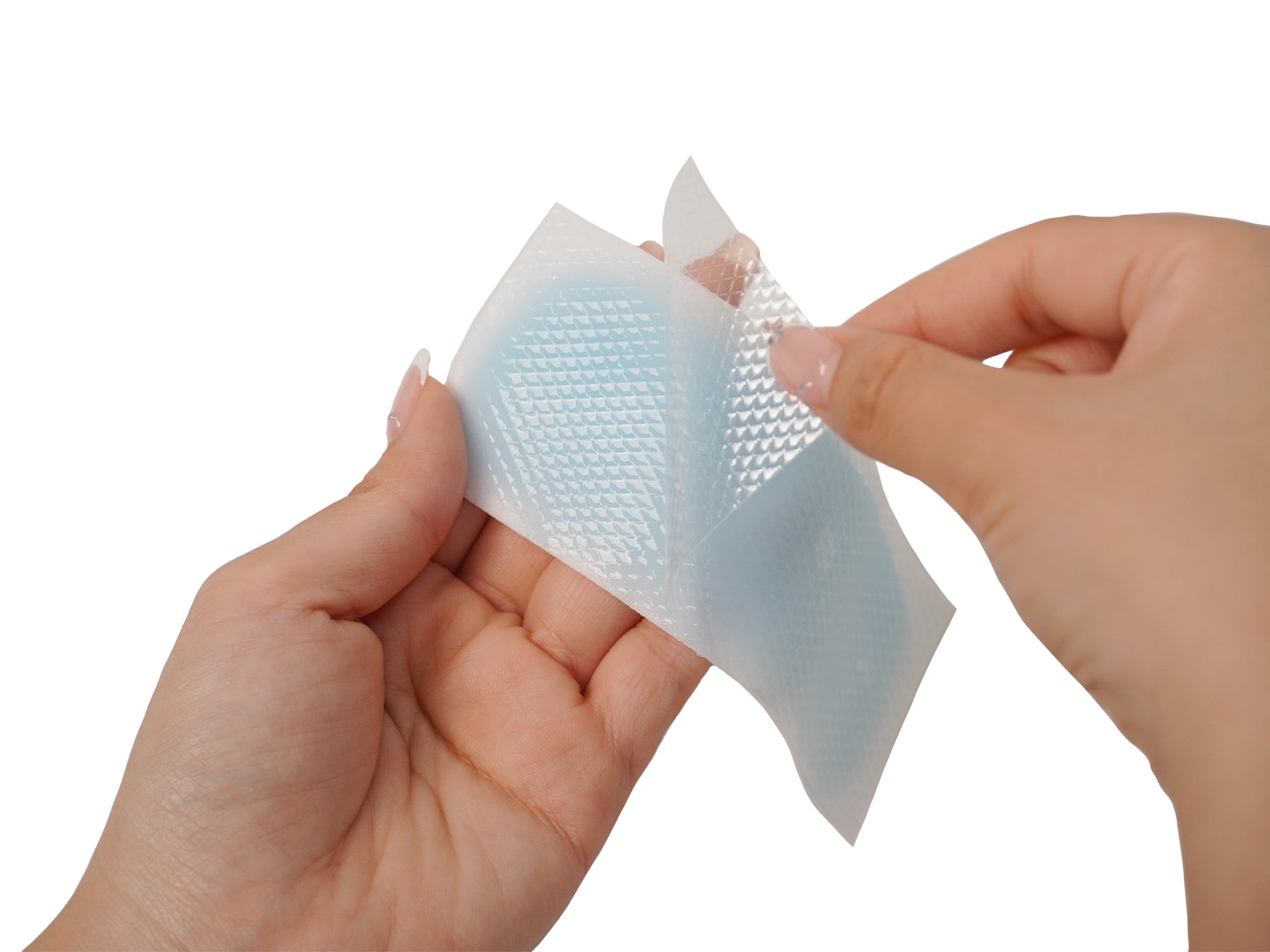 hands holding a baby fever cooling patch removing film before application