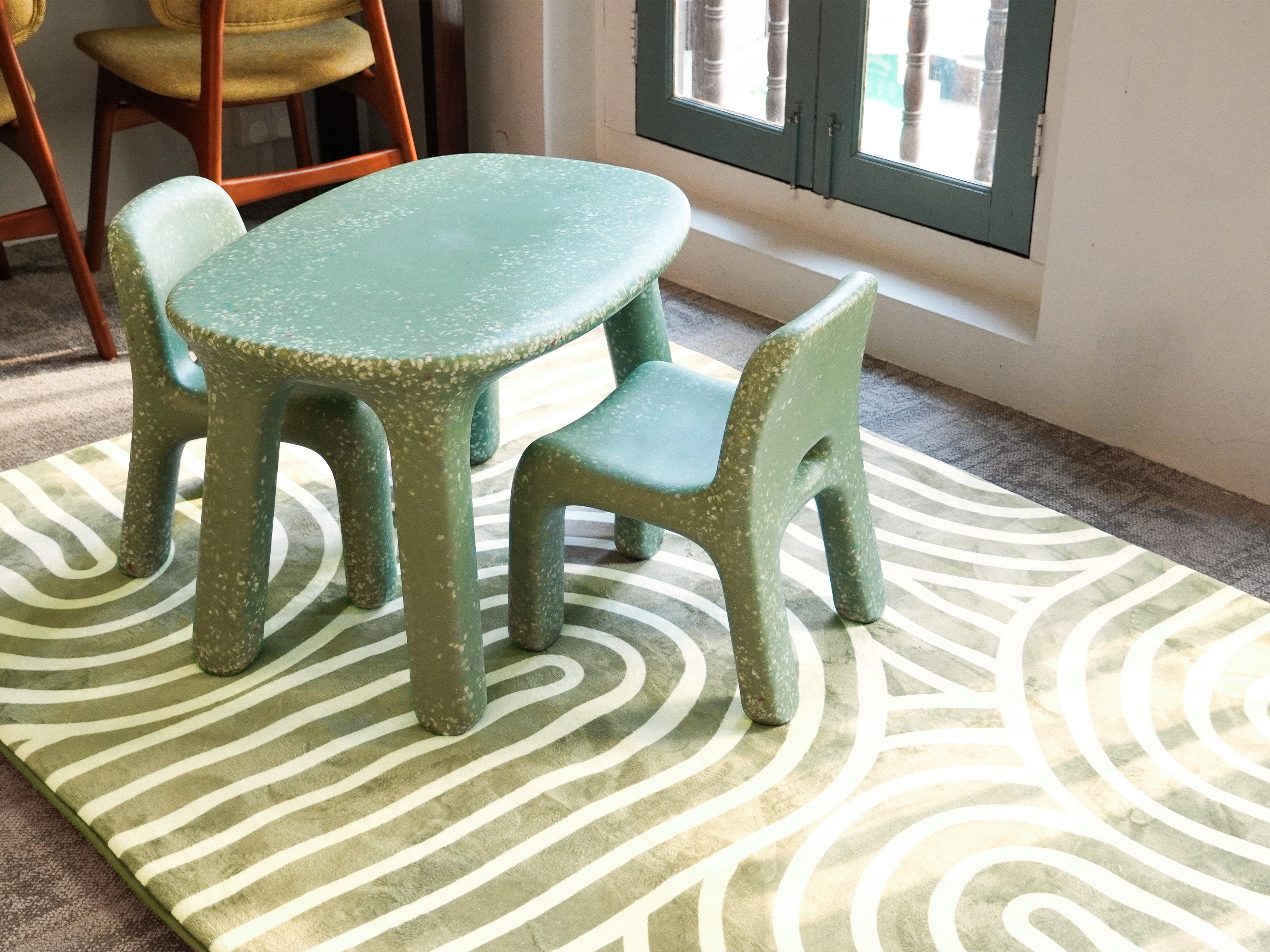 A small children table and chairs placed on top of the Lollibly Kaya Plush Playmat.