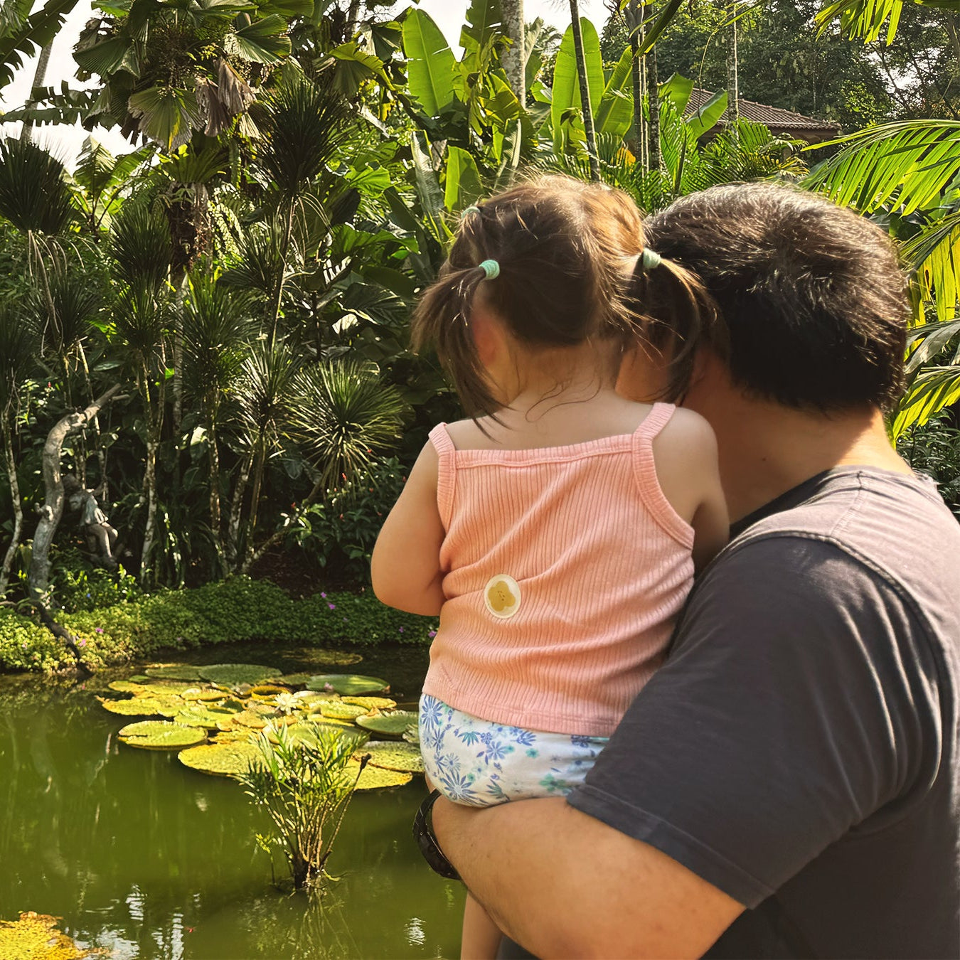 father and toddler in park with pond, toddler with mosquito repellent patch on shirt
