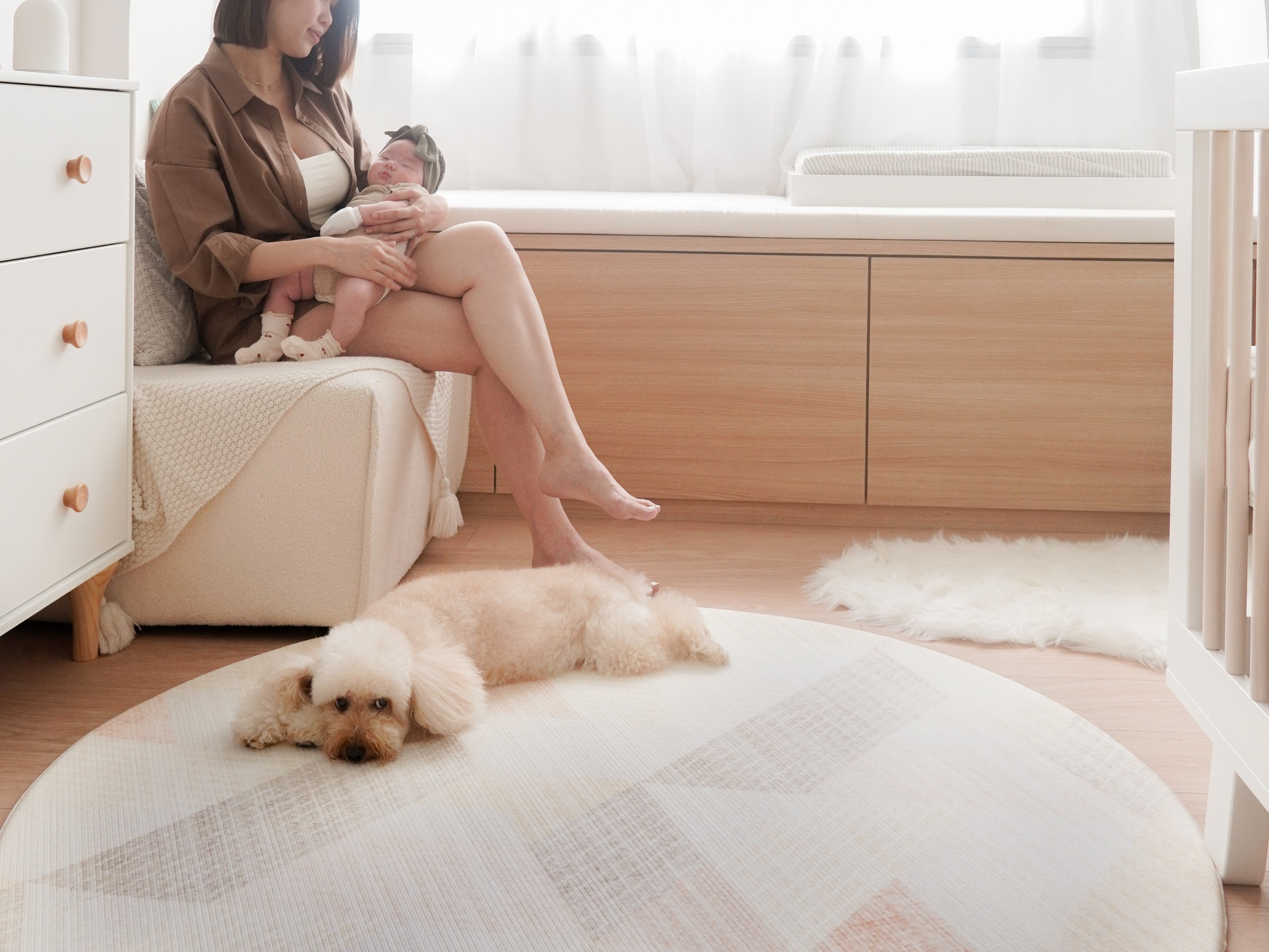 mom and baby on couch with dog resting on lollibly sand dune play mat