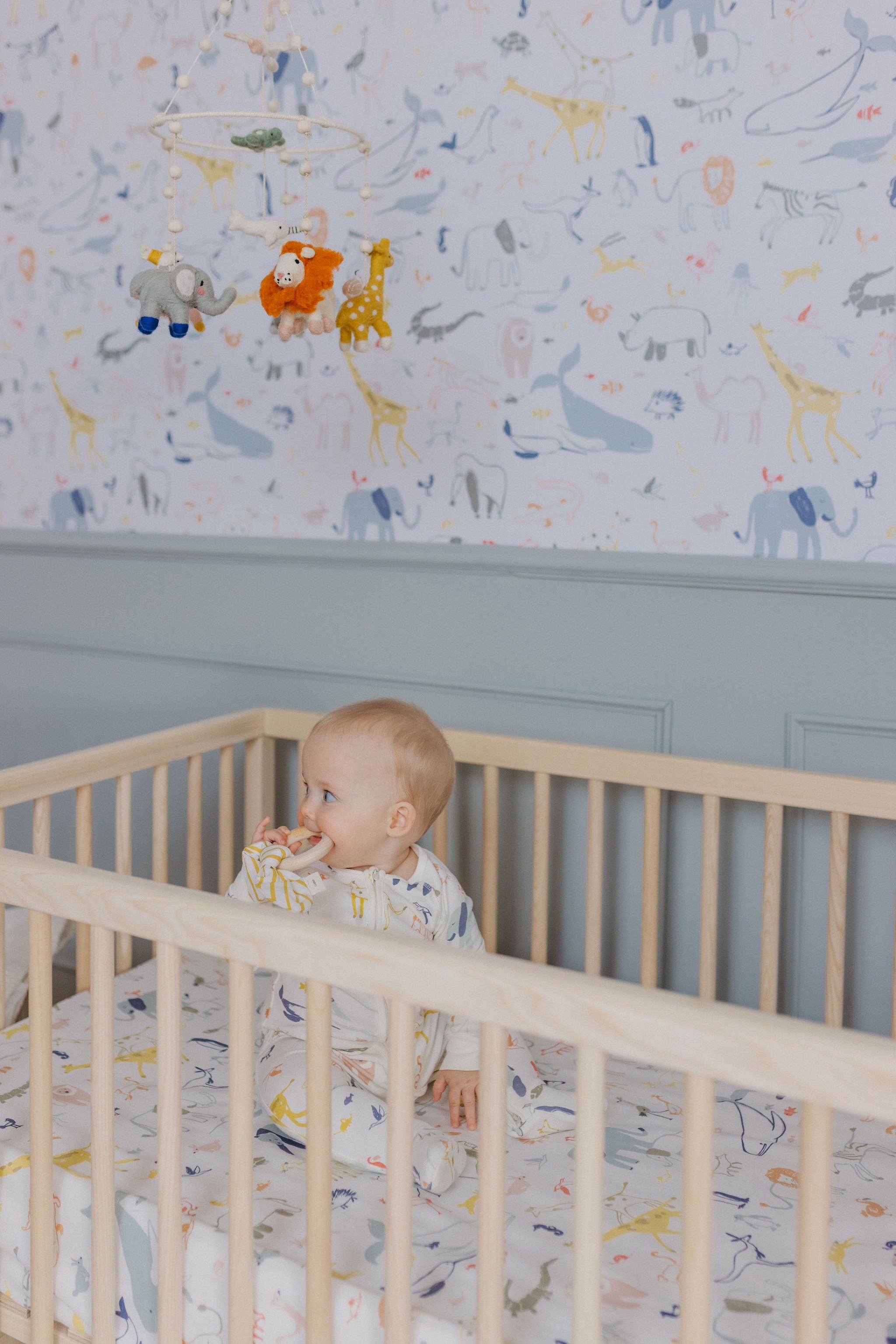 baby boy in crib with nursery decorated with into the wild print