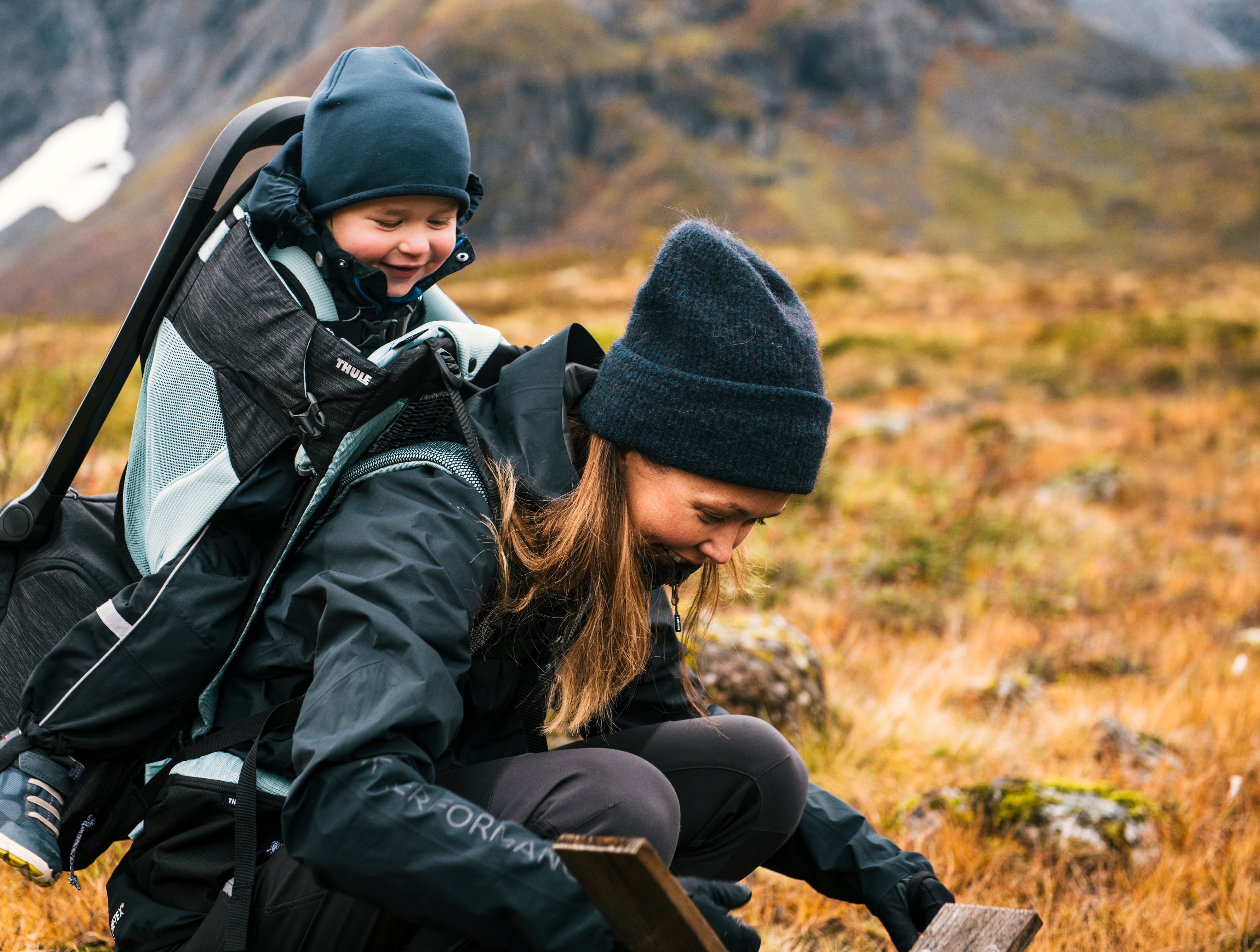 mum and child on outdoor adventure playing with child sitting in Thule Child Carrier Backpack Sapling