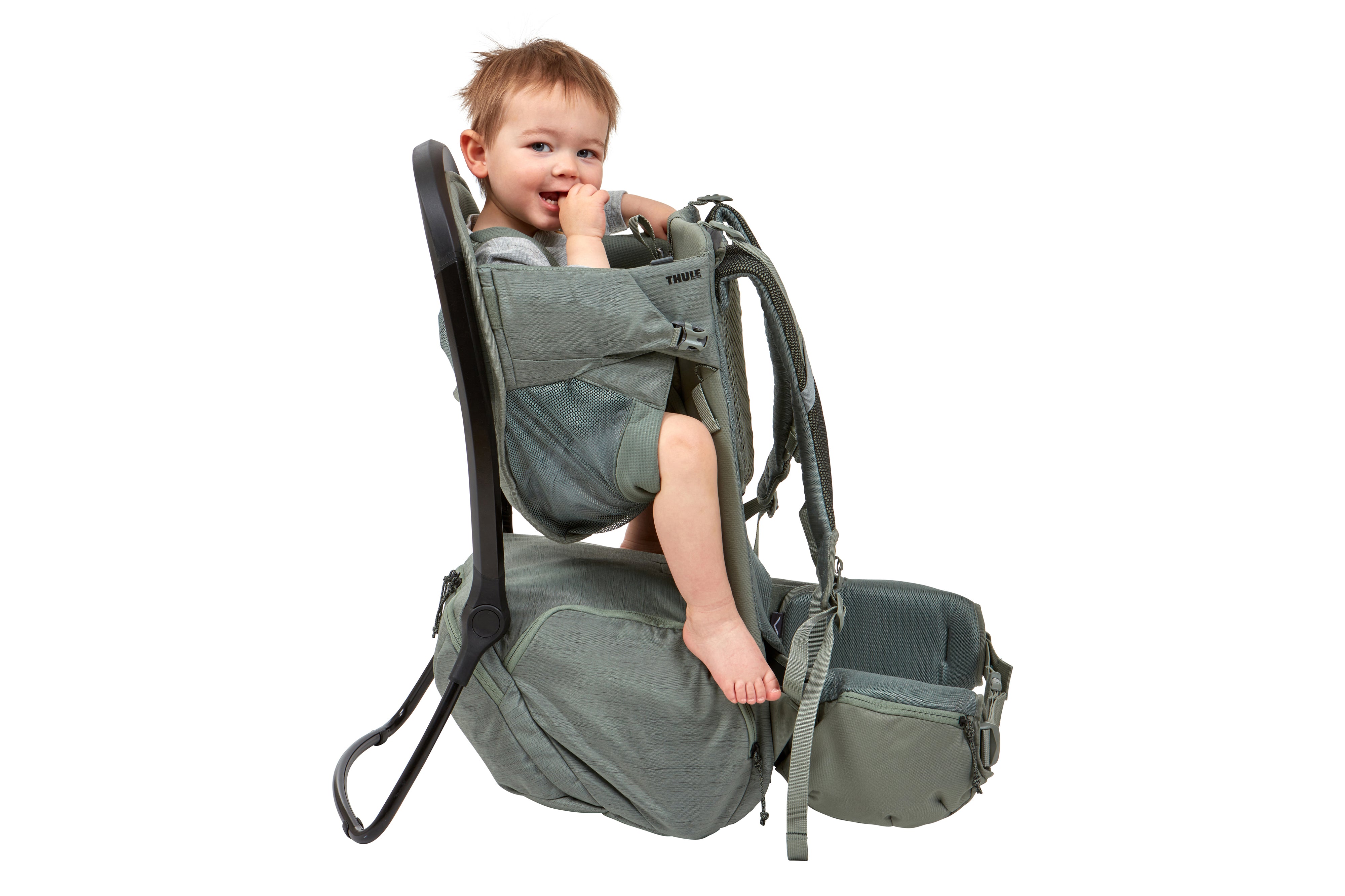 Toddler sitting in Thule Child Carrier Backpack Sapling Agave Green