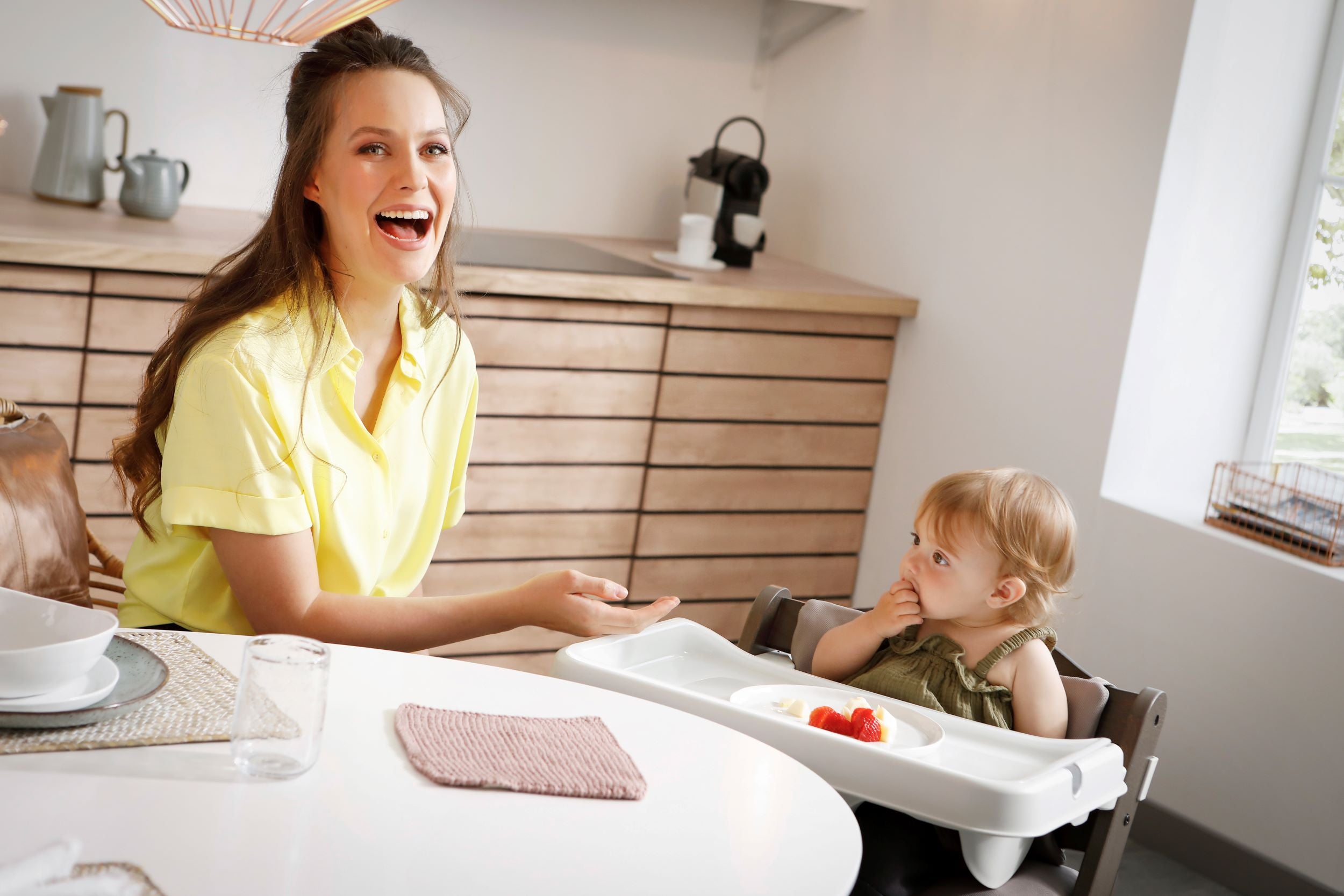 close up of baby on alpha high chair with tray attachment