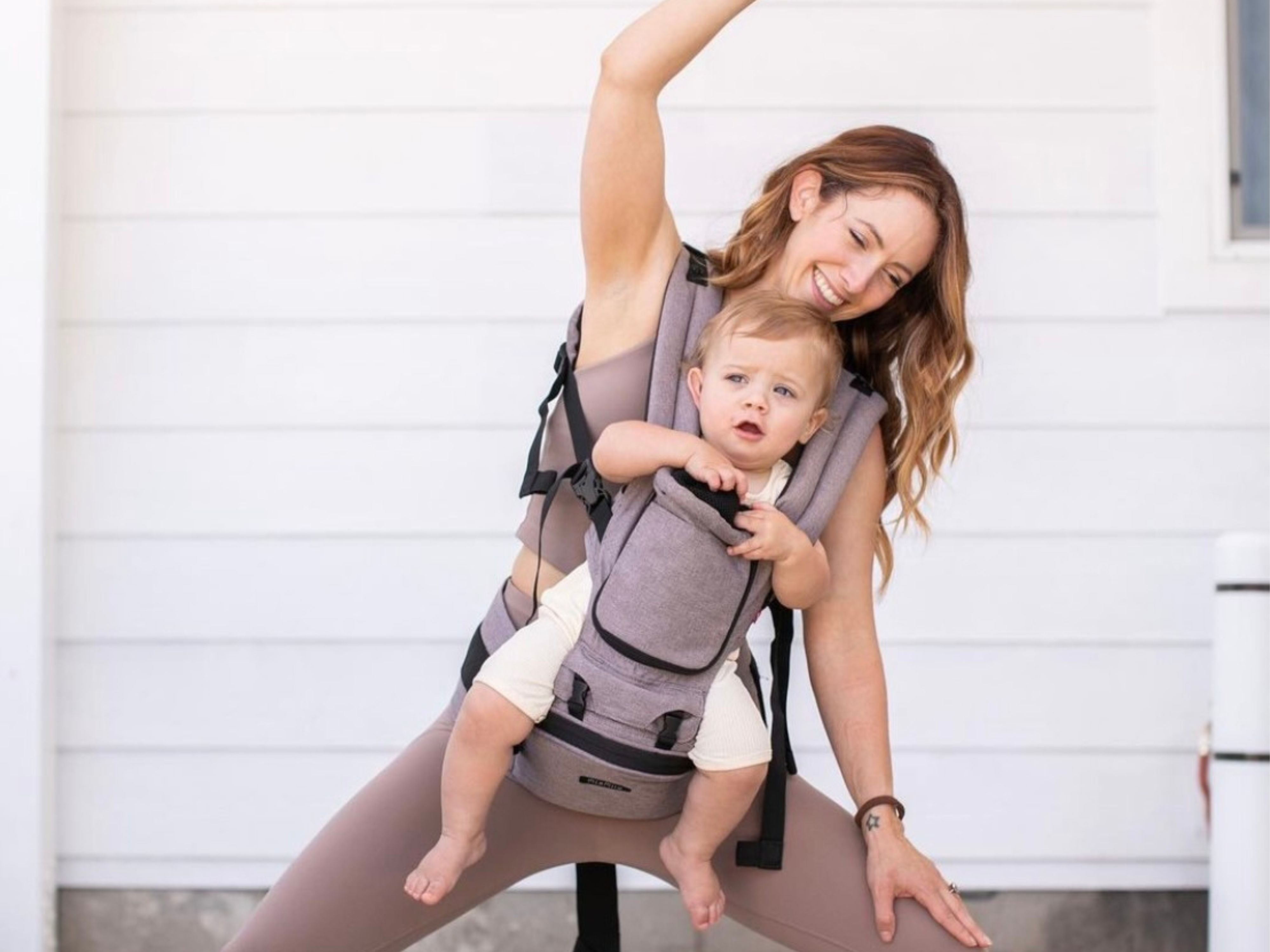 mom carrying baby in hipster plus stone grey while doing yoga#color_stone-grey