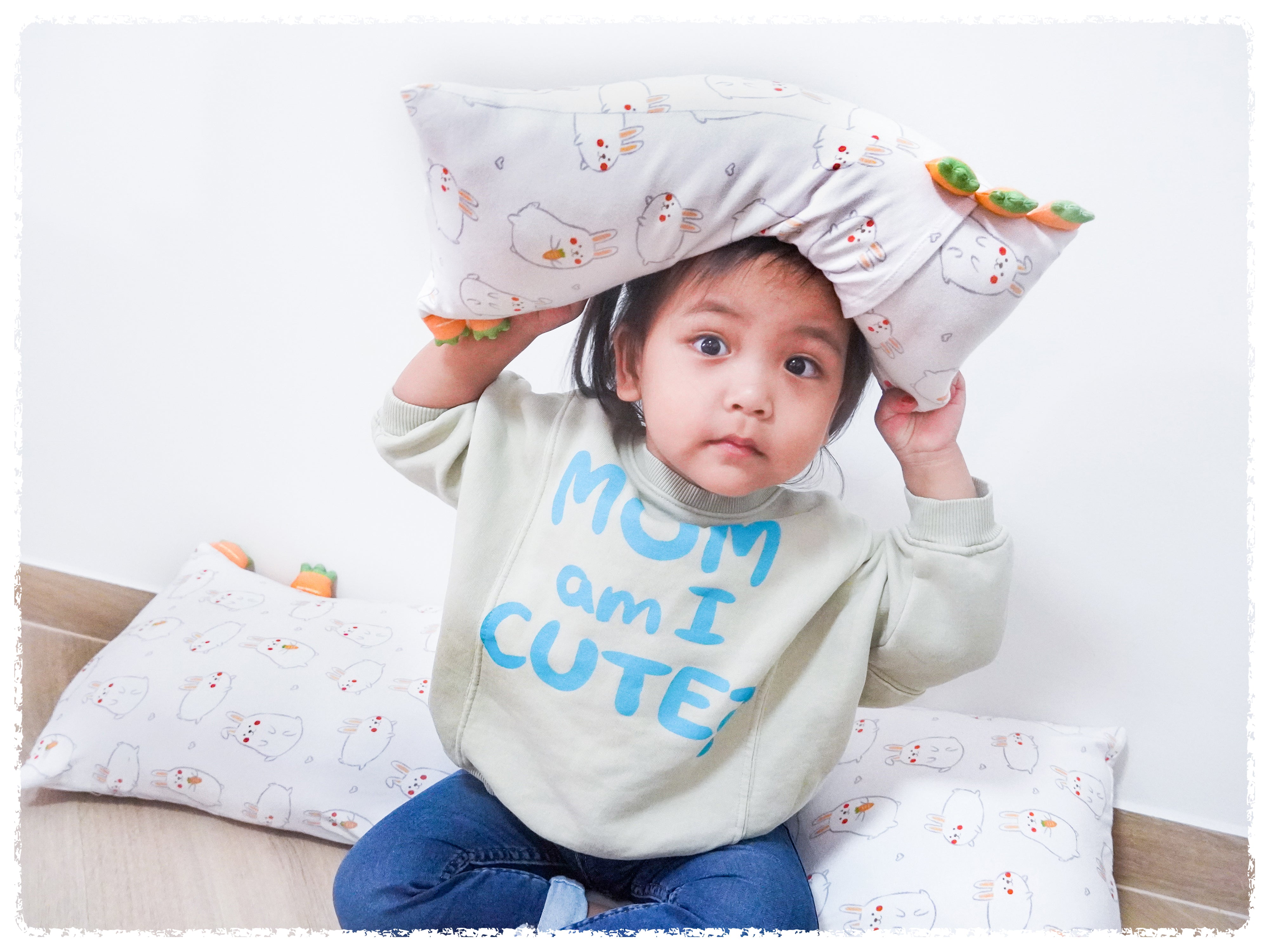 little girl holding momo bunny cho pillow over her head