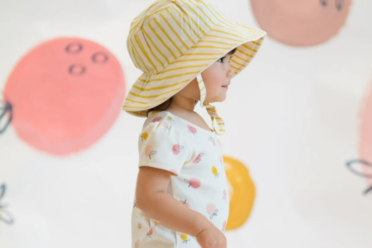toddler wearing pehr bucket hat and romper